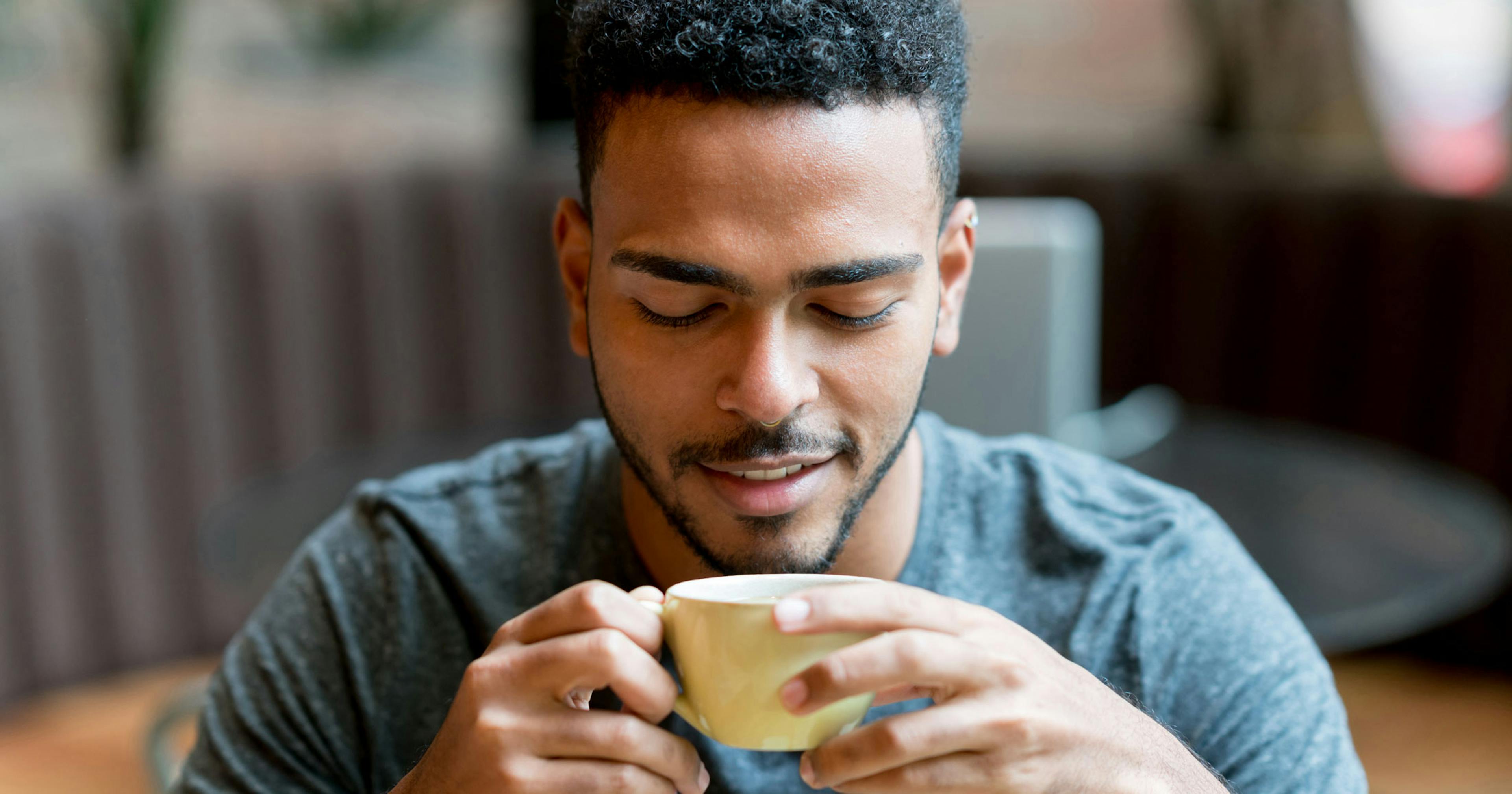 Happy man drinking a cup of coffee.