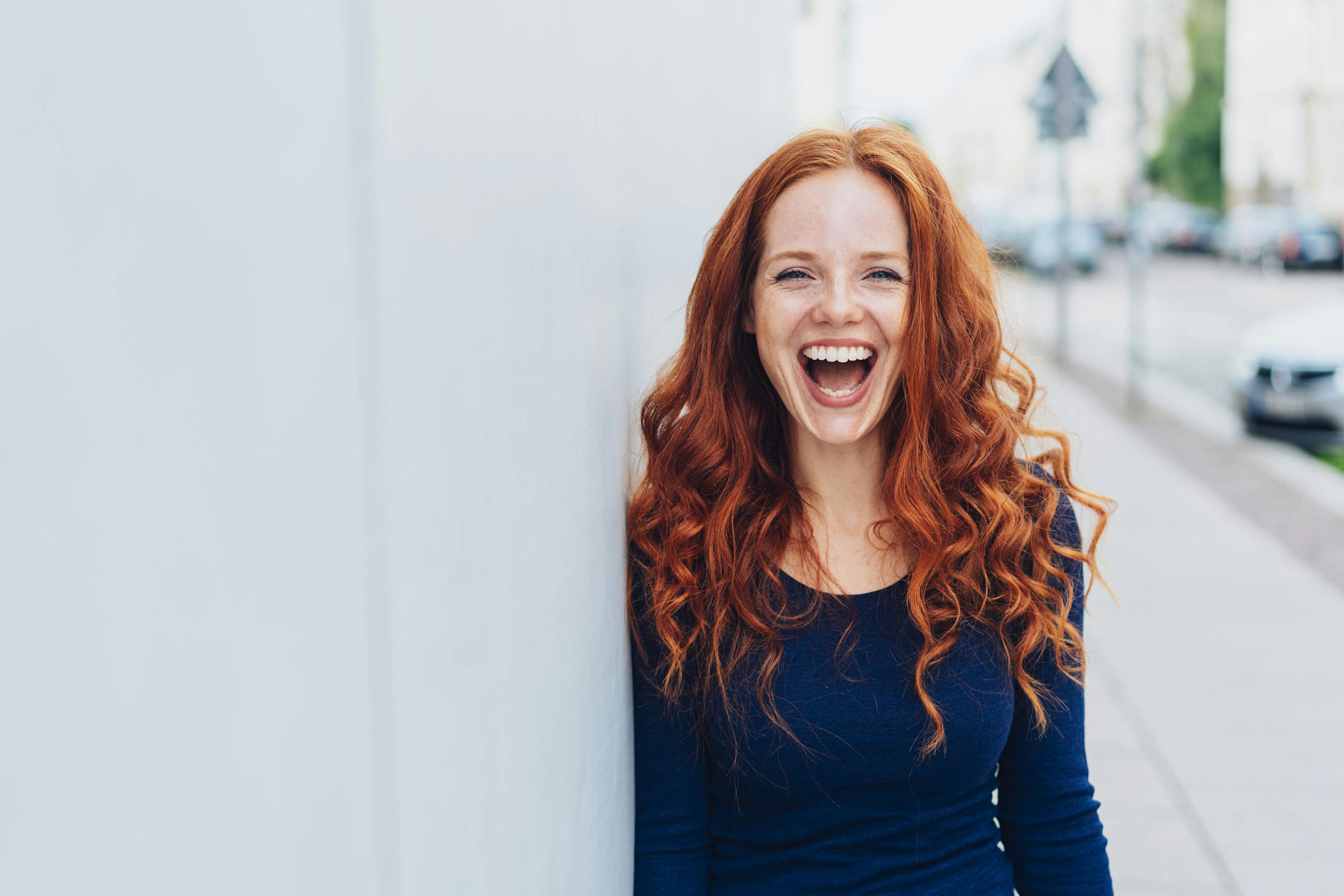 happy redheaded woman outside smiling