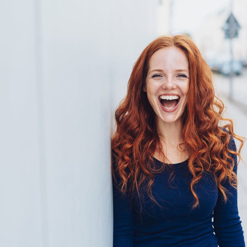 happy redheaded woman outside smiling