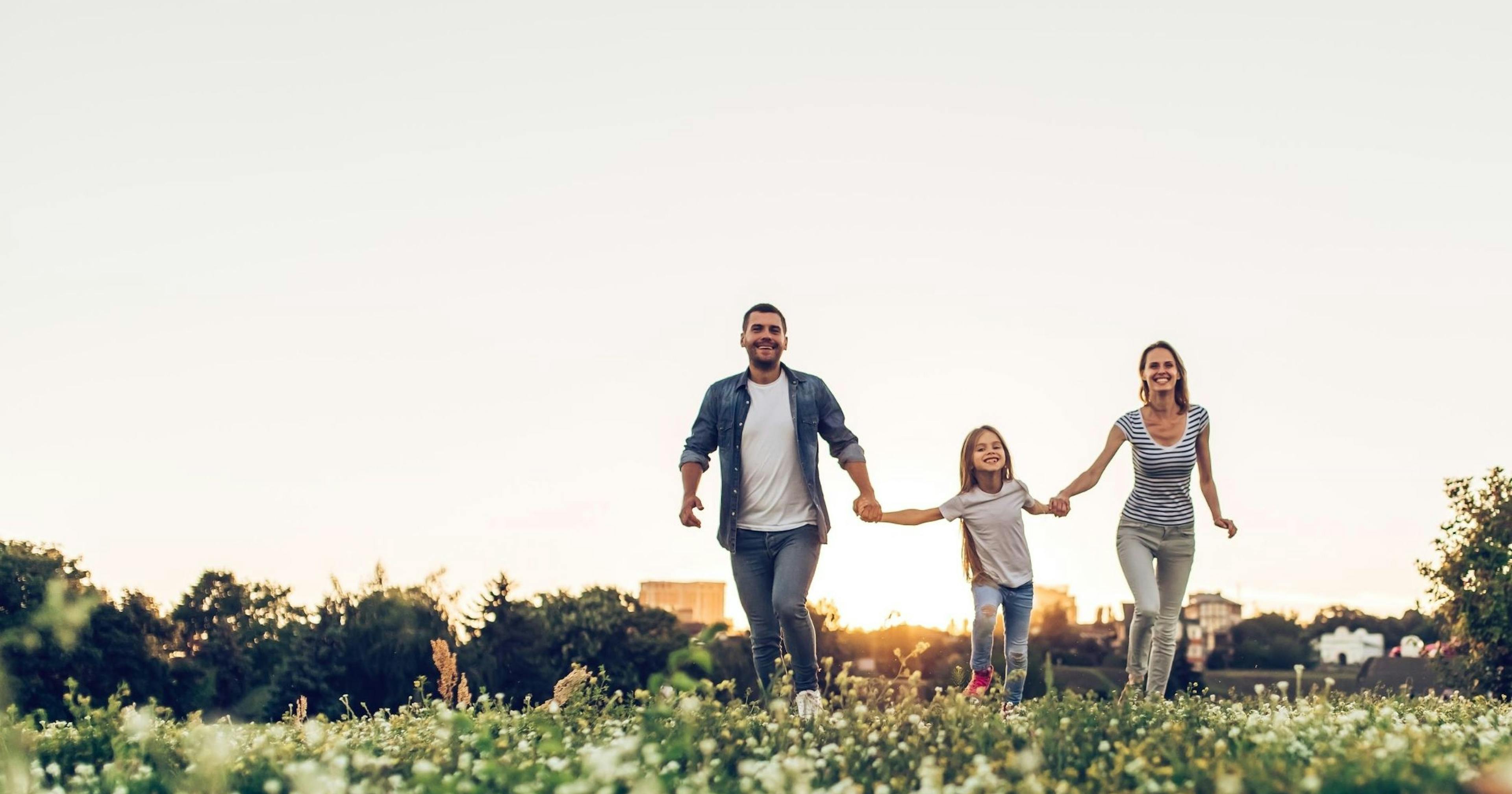 happy family walking through field