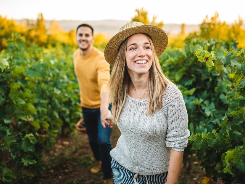 woman leading man through a vineyard