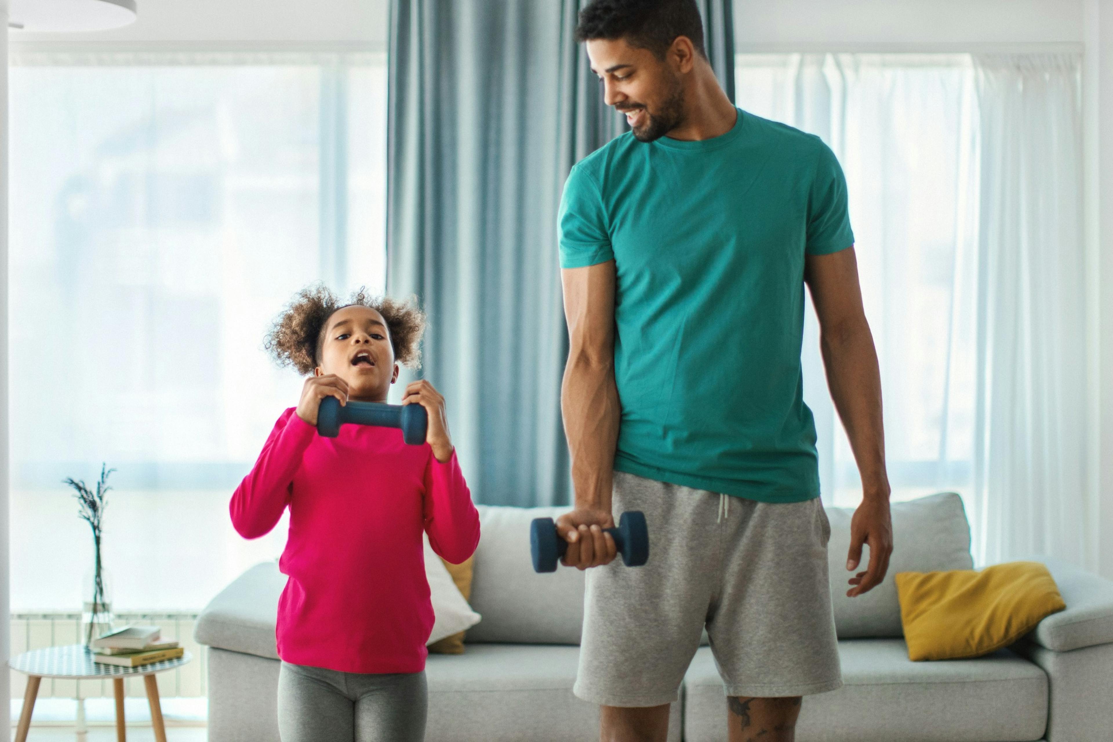 father and daughter lifting weights