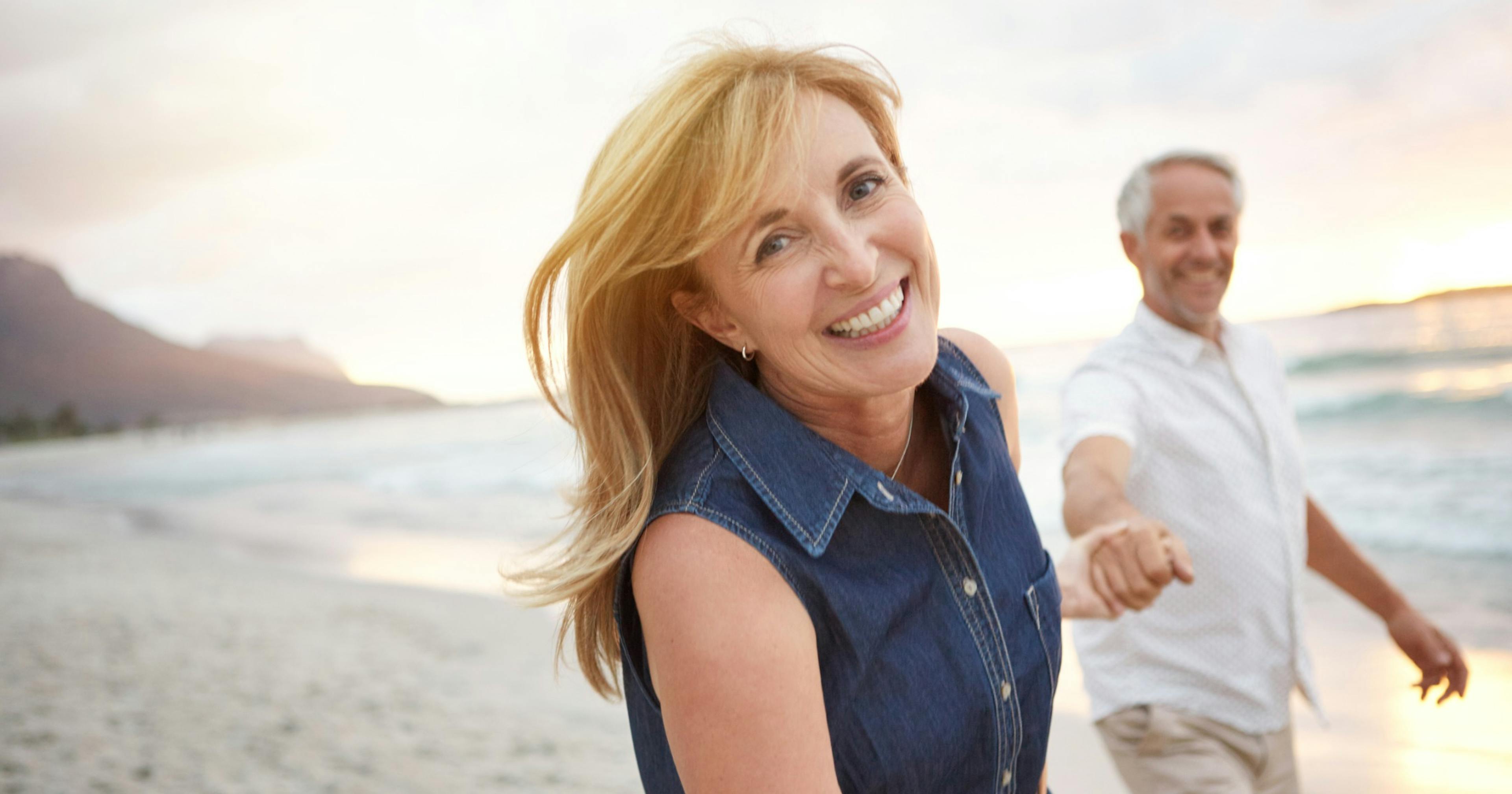 happy middle age couple on the beach