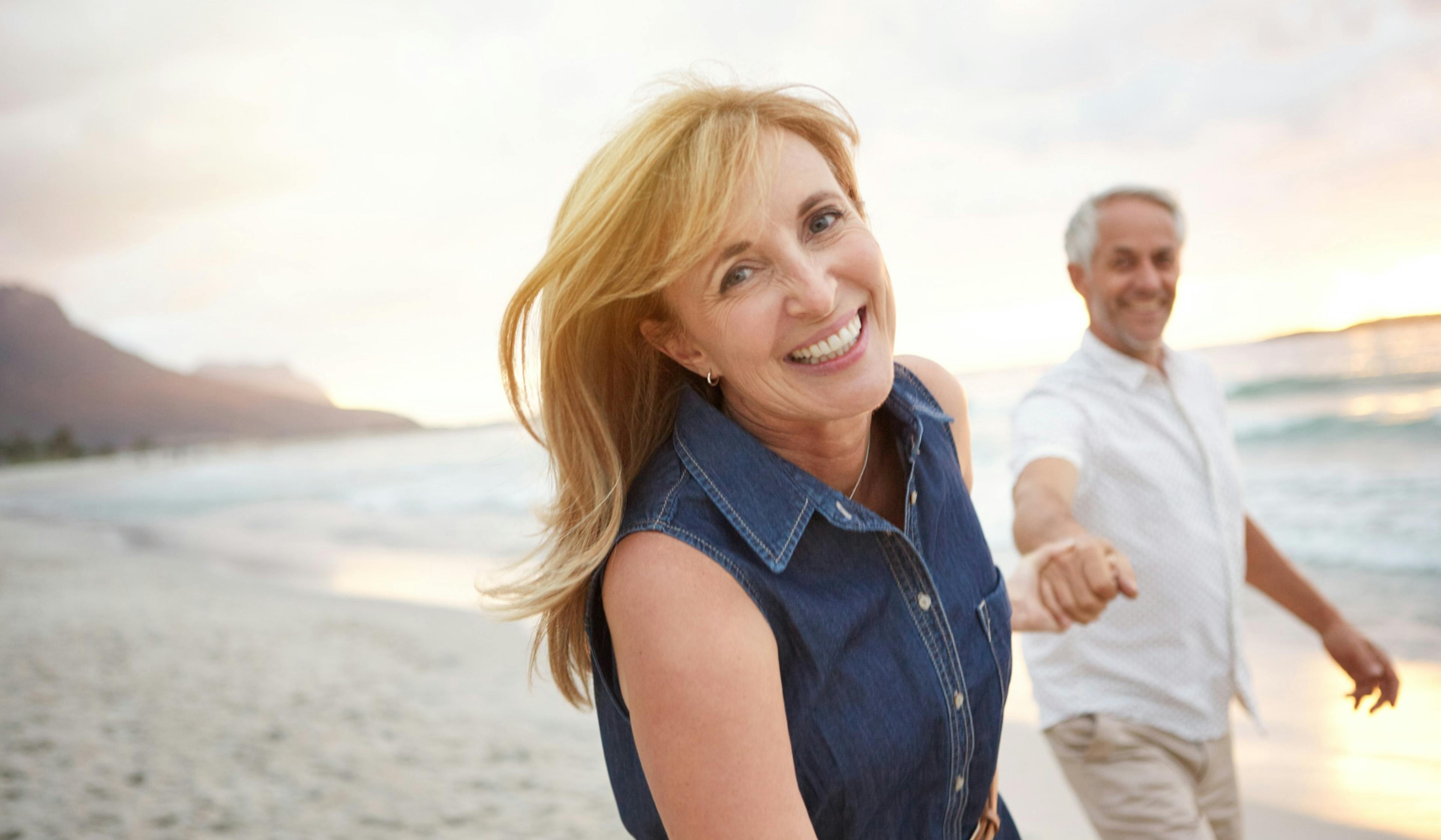 happy middle age couple on the beach