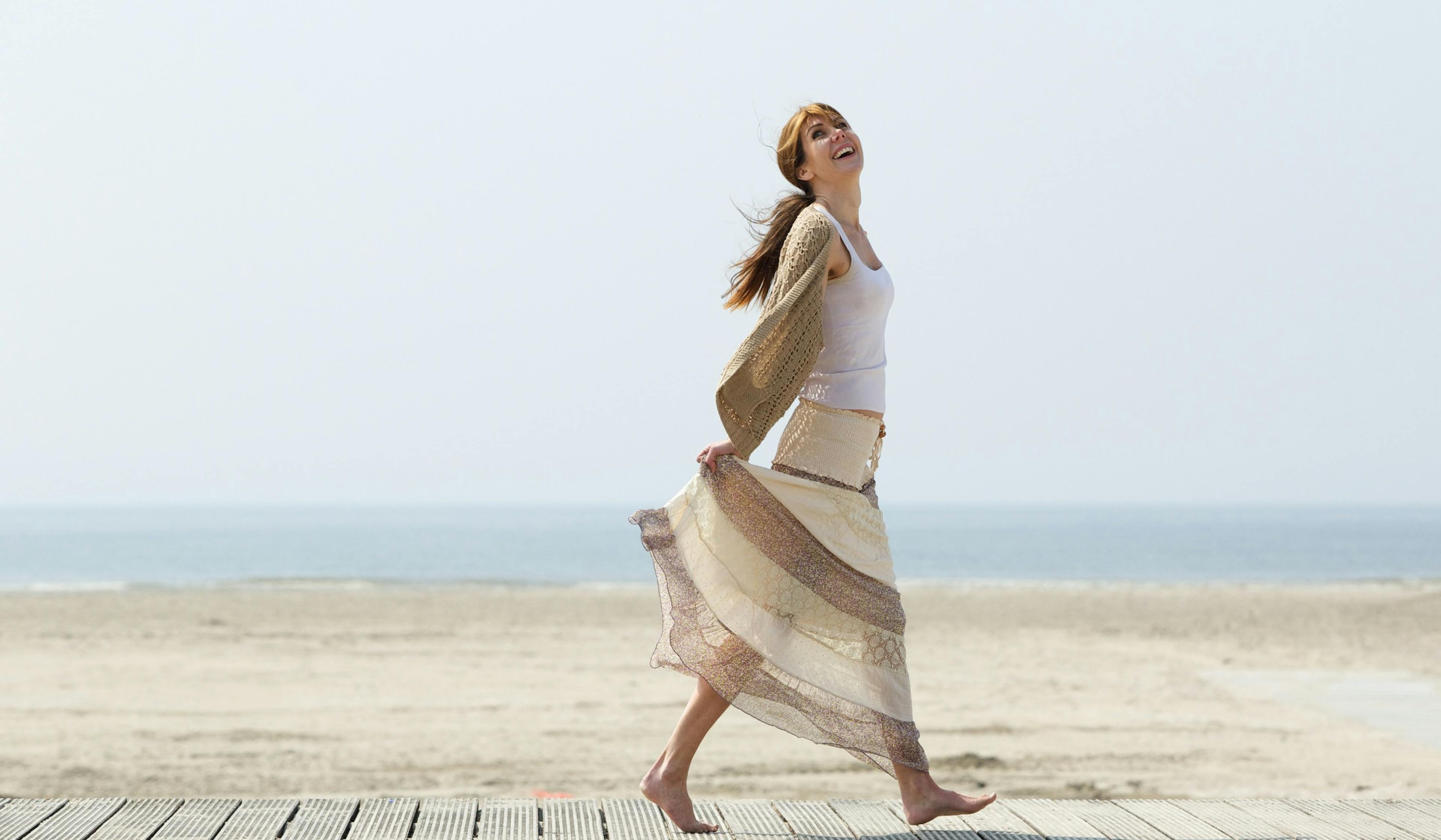 carefree woman walking at the beach