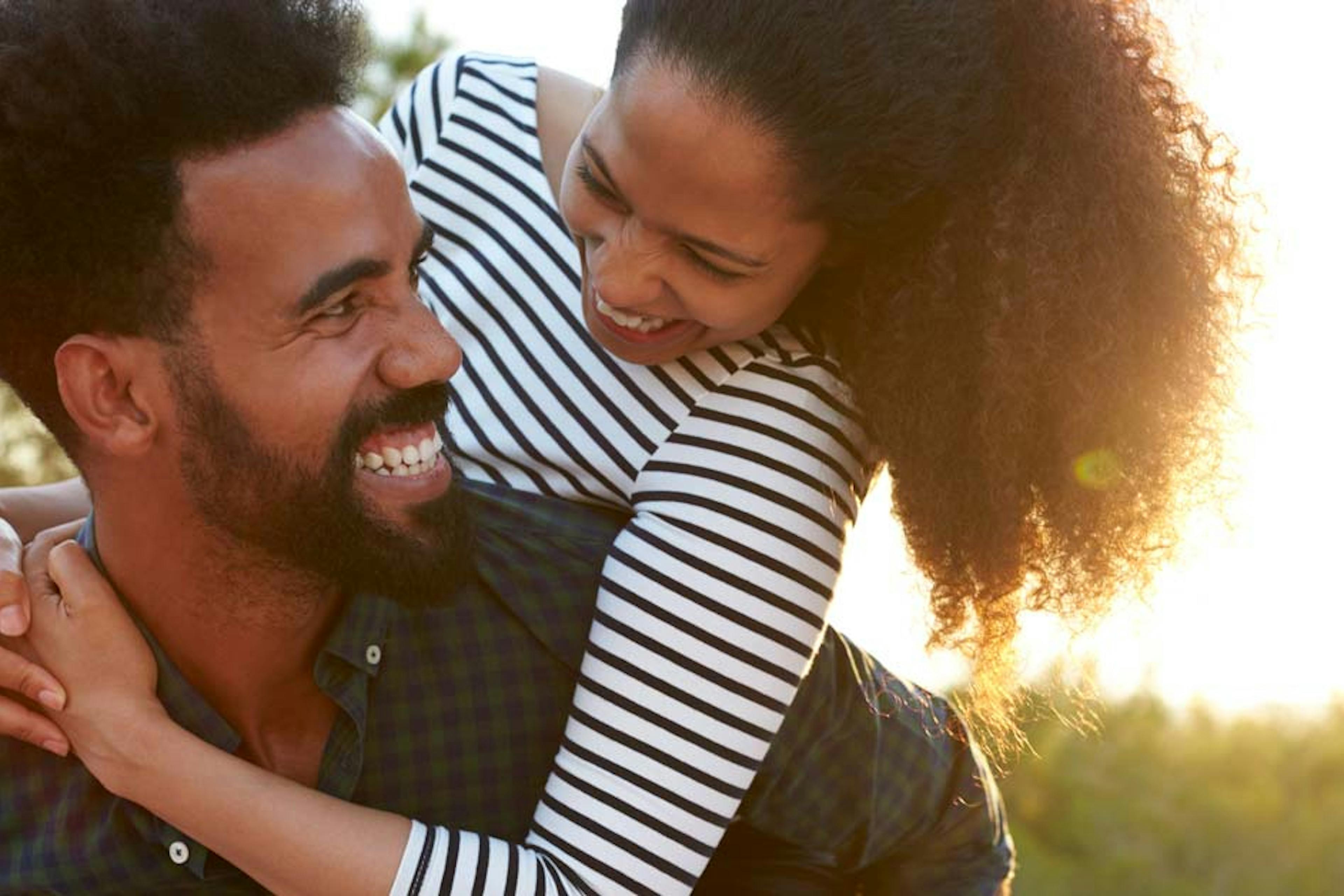 happy man carrying a woman on his shoulders