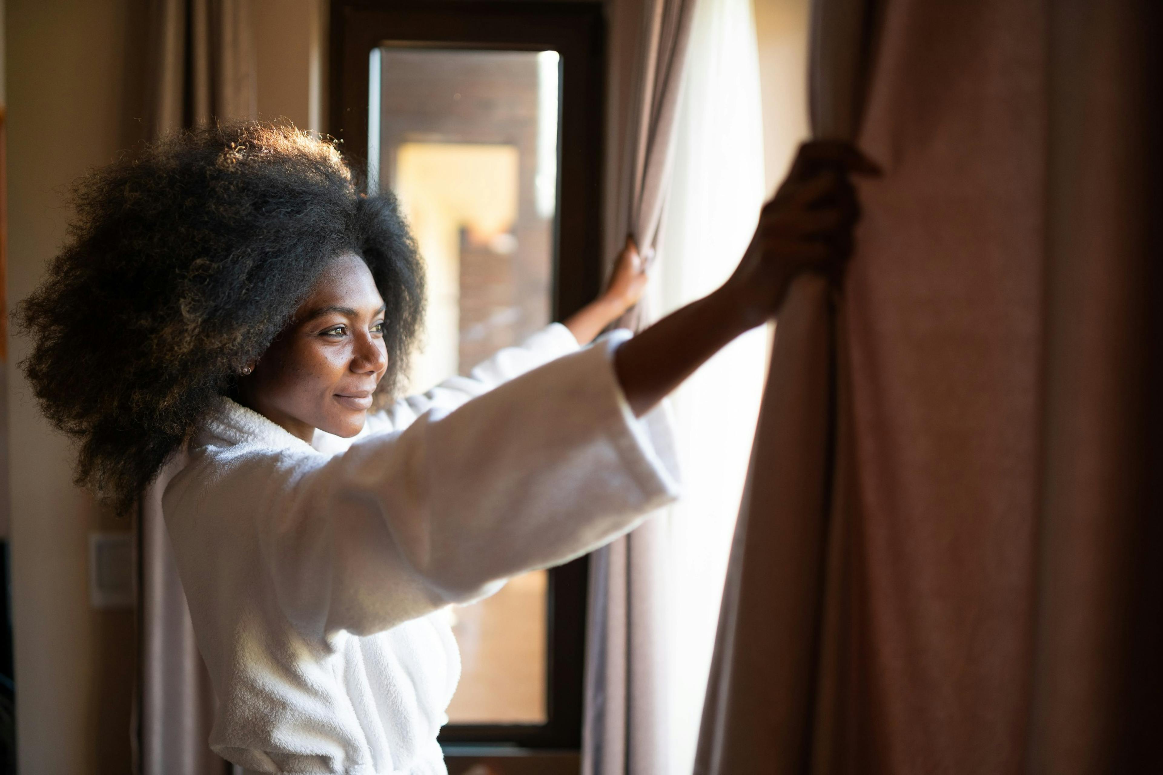 woman pulling open the curtain