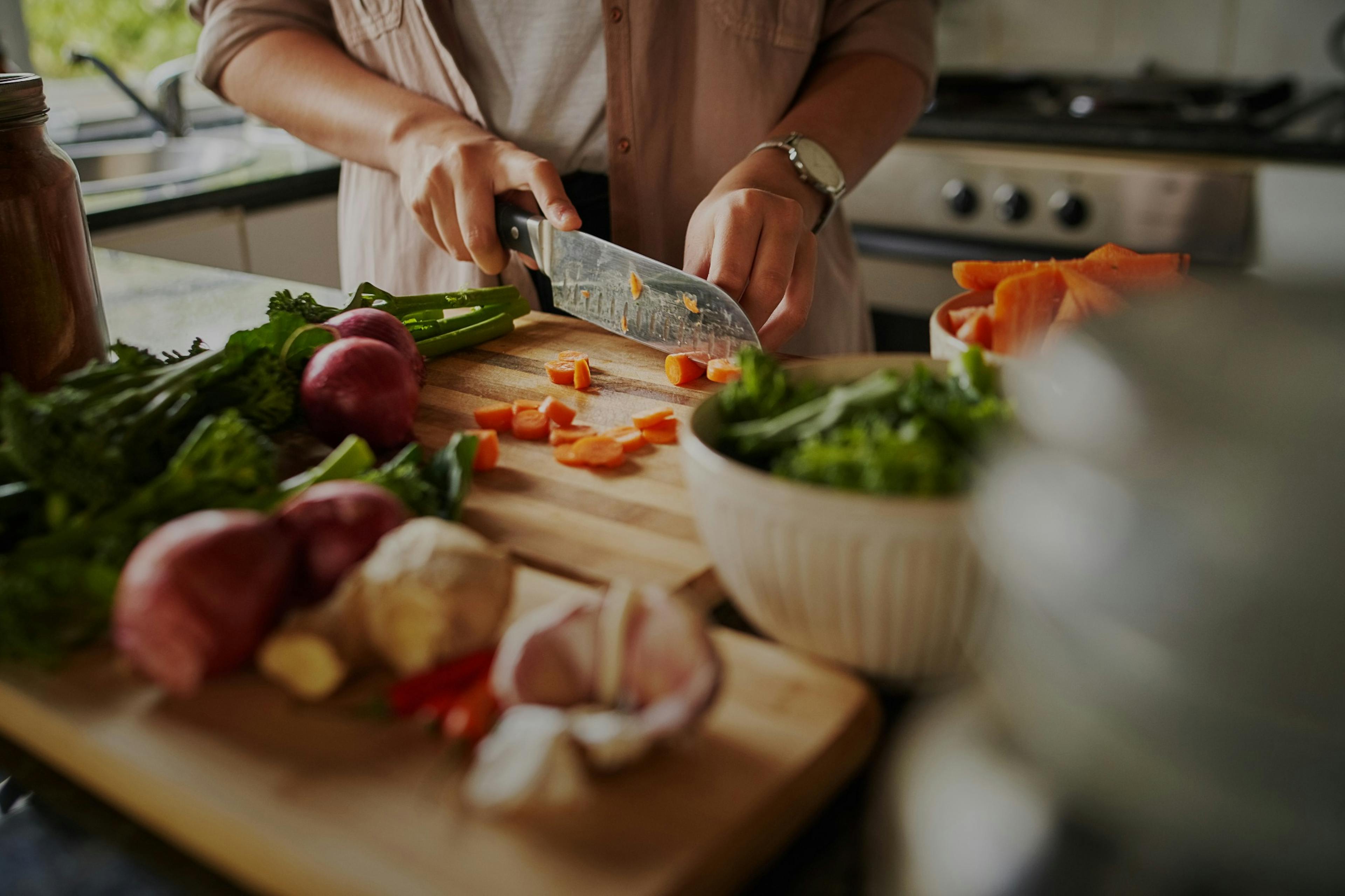 young woman chopping fresh vegetables