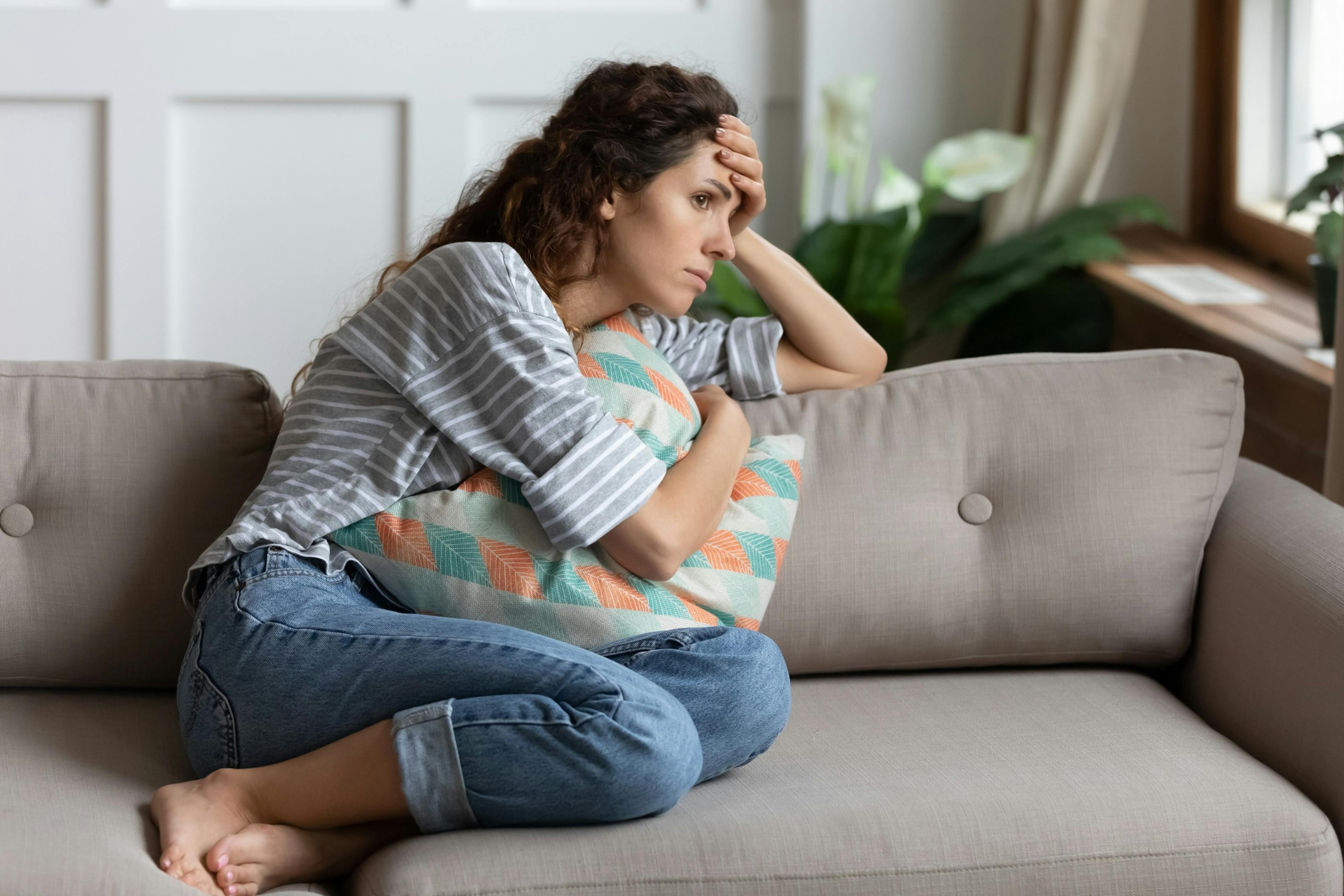 woman not feeling good sitting on couch