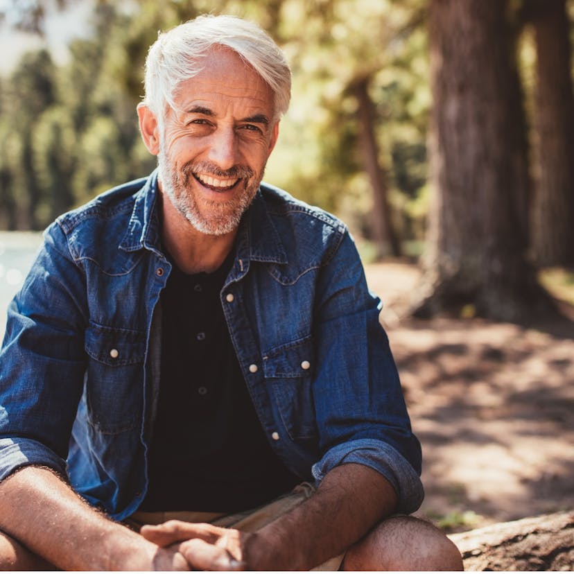 Mature man sitting at the lake. 