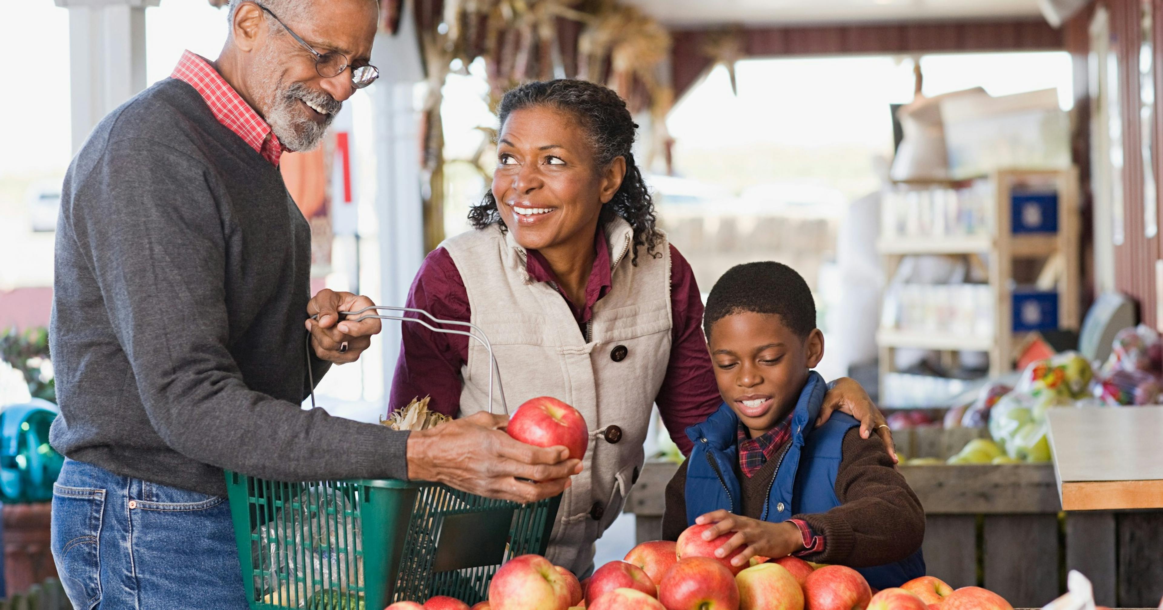 grandparents buying fruit with their grandson