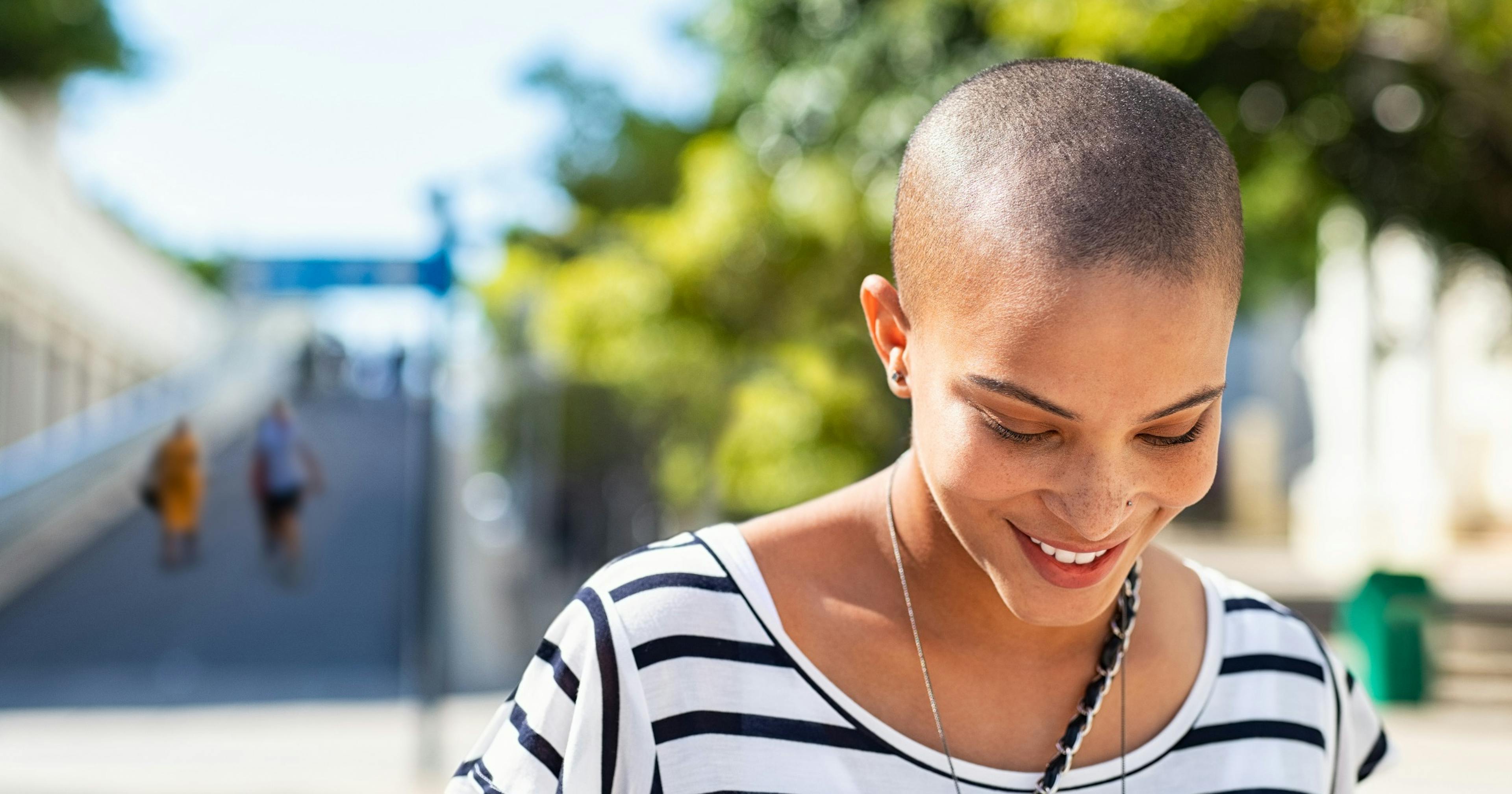 Young carefree cancer survivor walking in the sunshine.