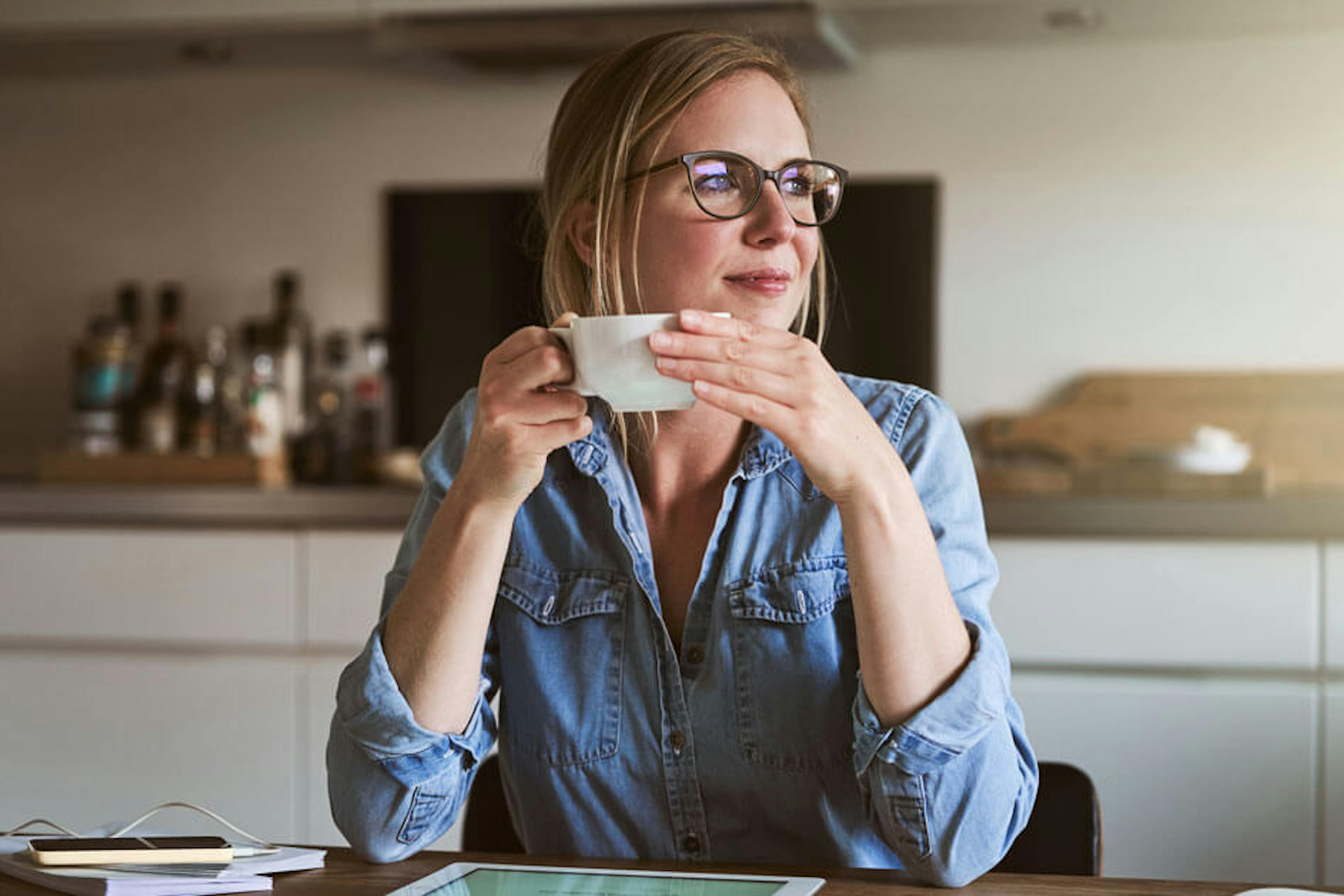 woman at kitchen table looking toward the sunlight