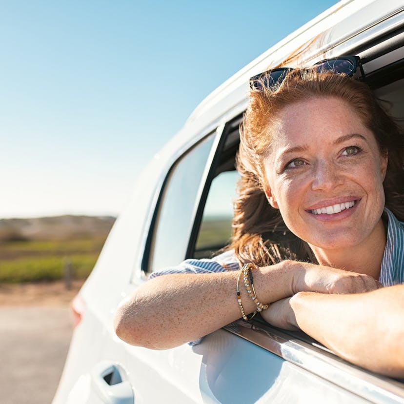 woman looking out car window smiling