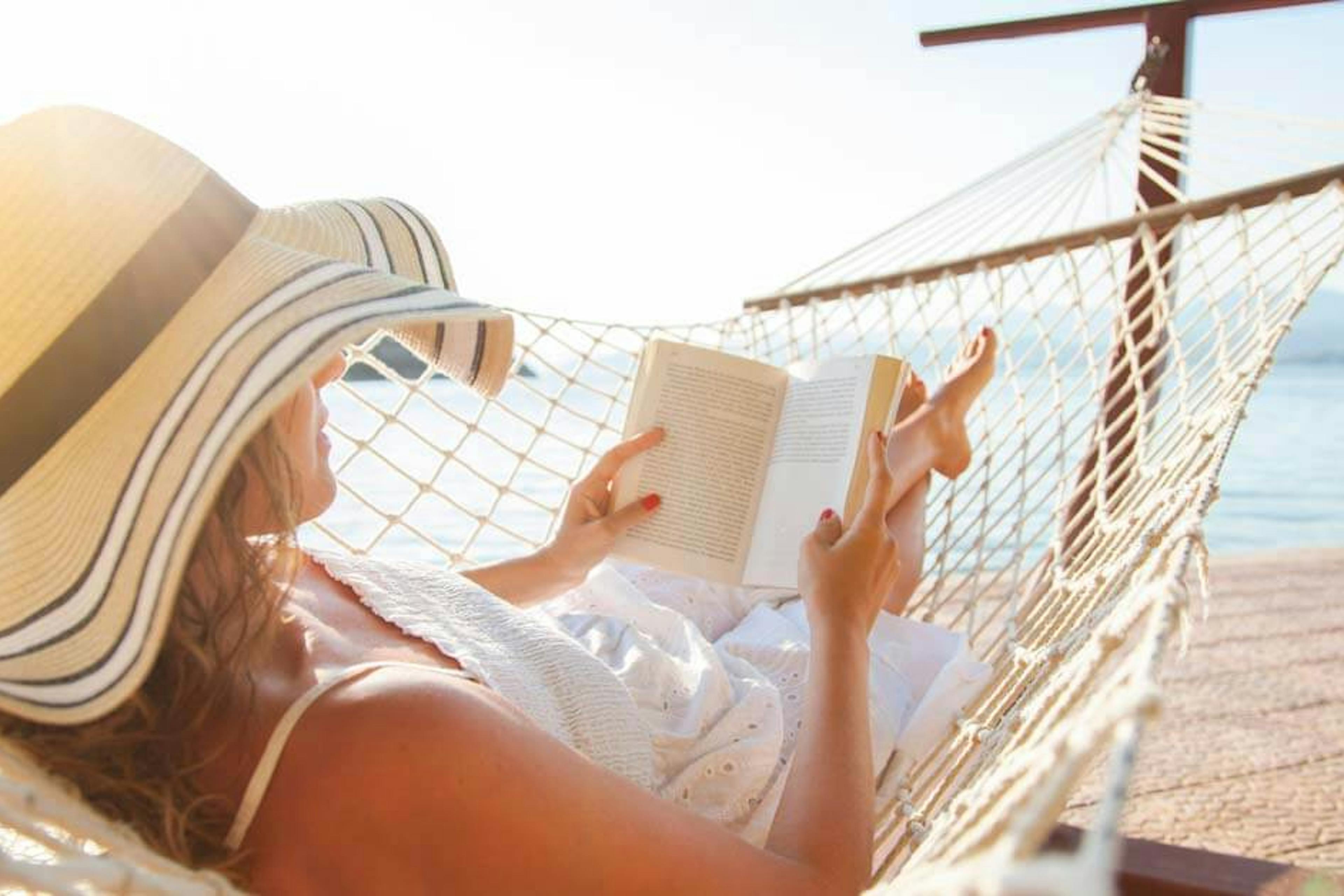 Young woman reading on the beach.