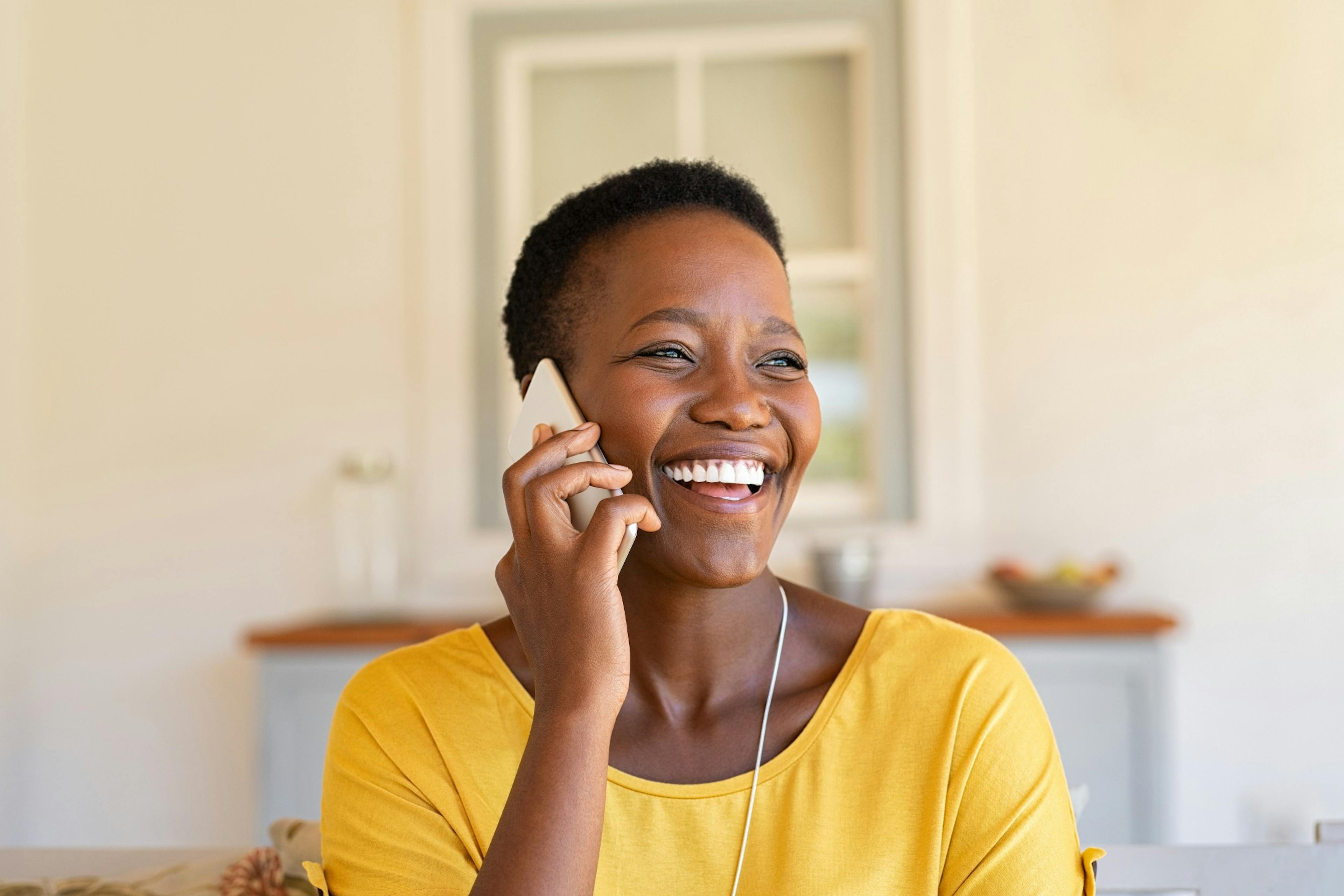 woman laughing and talking on the phone