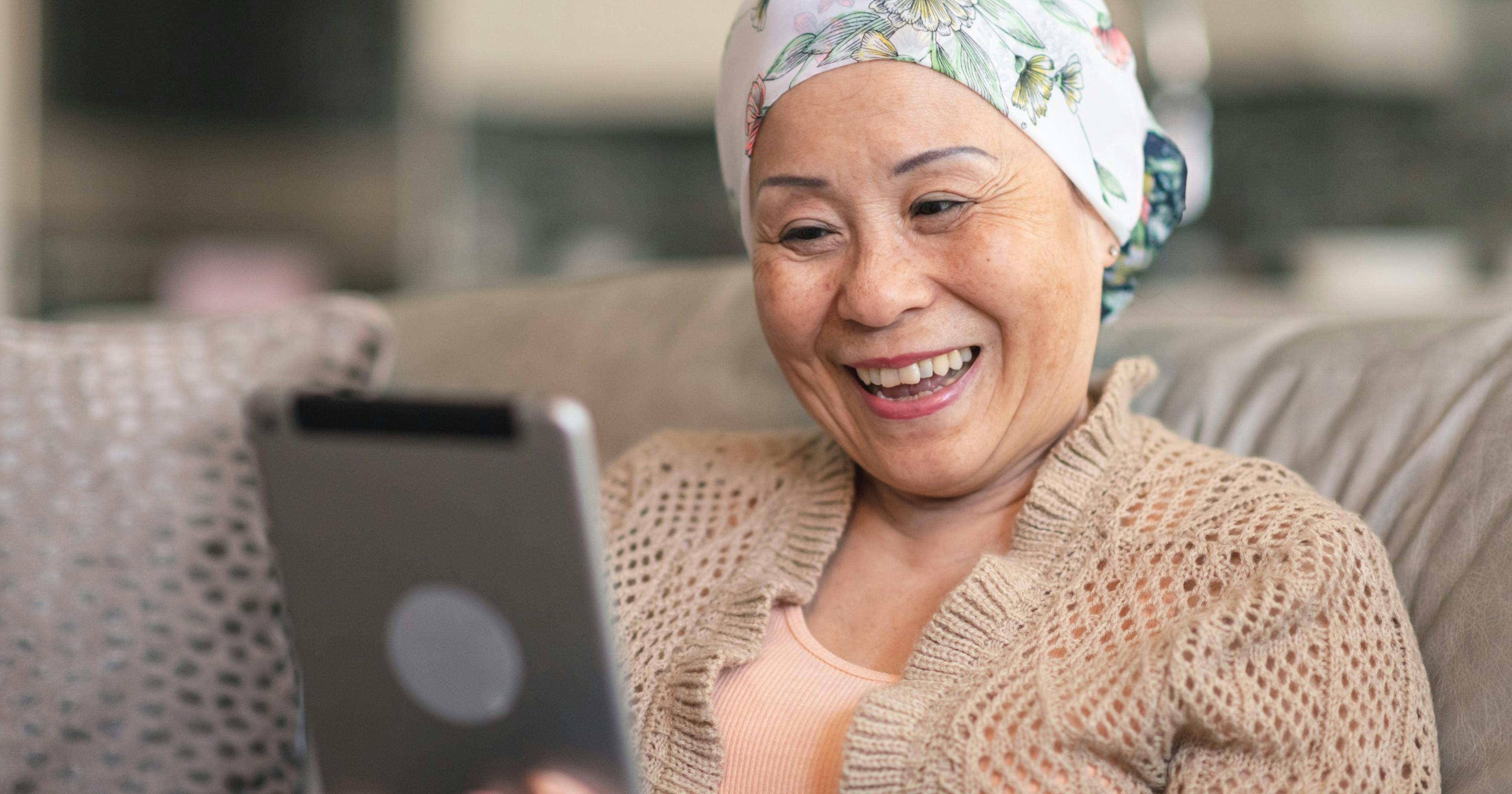 woman with cancer reads information on a tablet