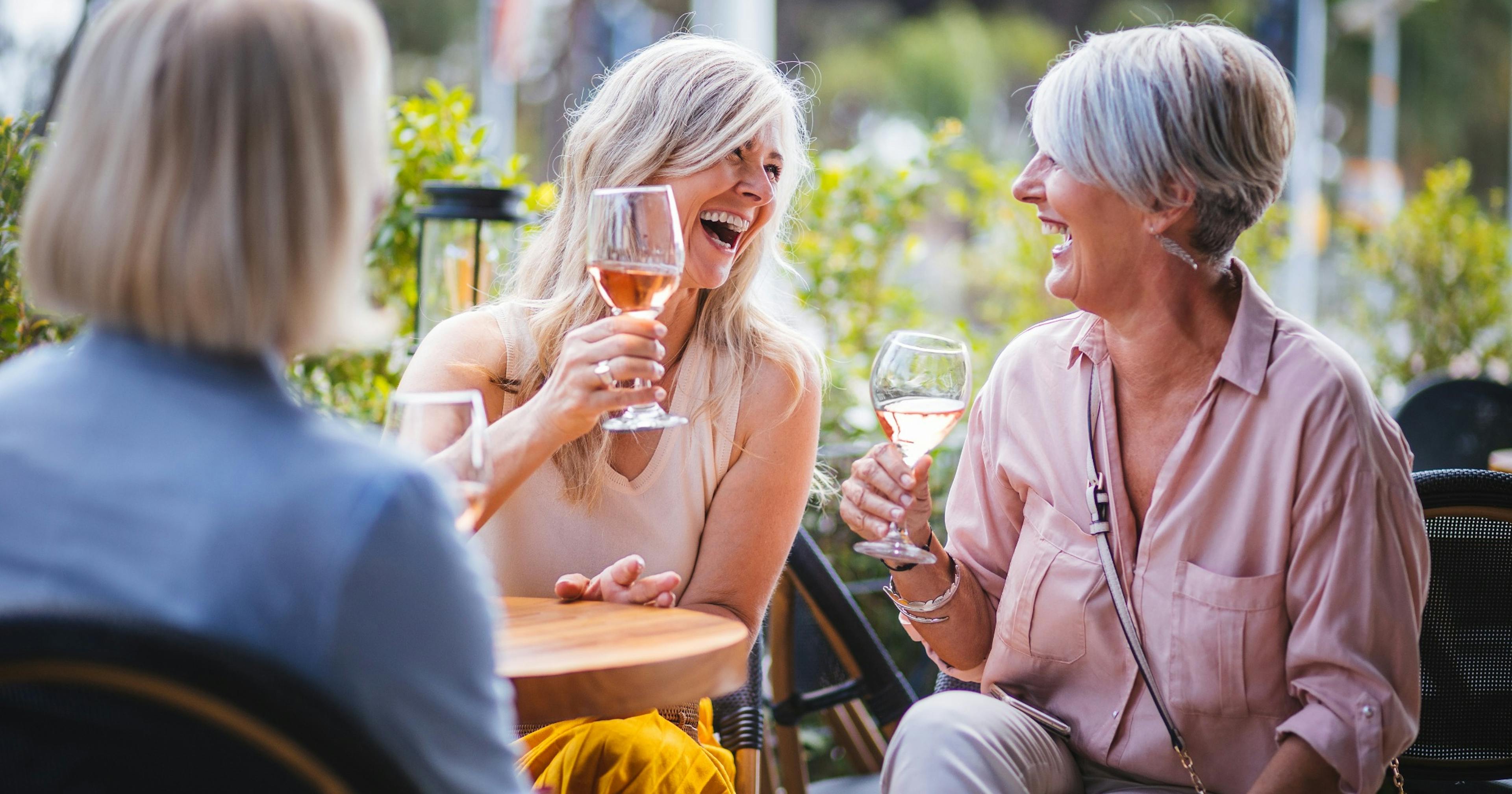 happy senior aged women drinking wine at a restaurant