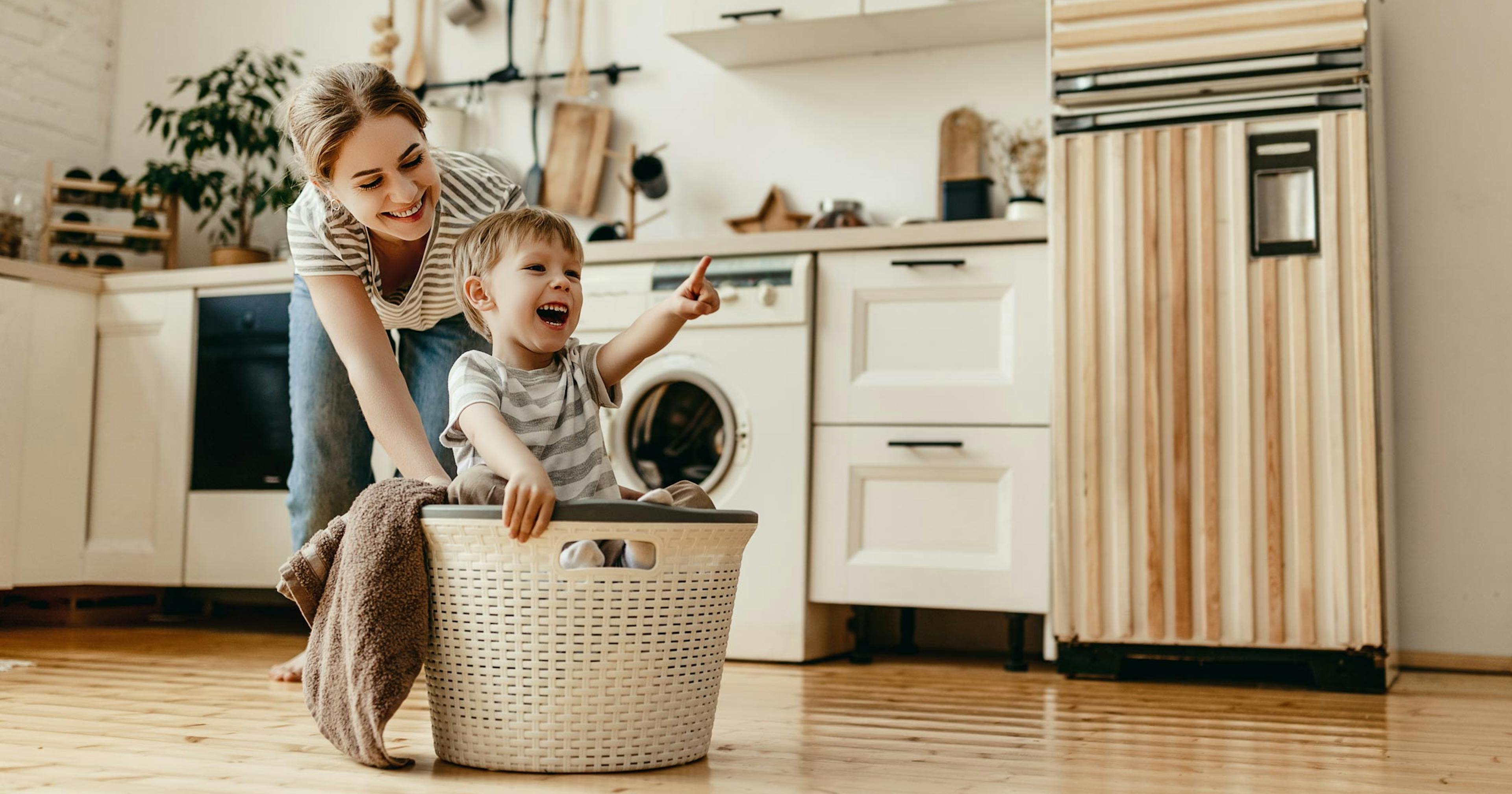 happy mom doing laundry with her son