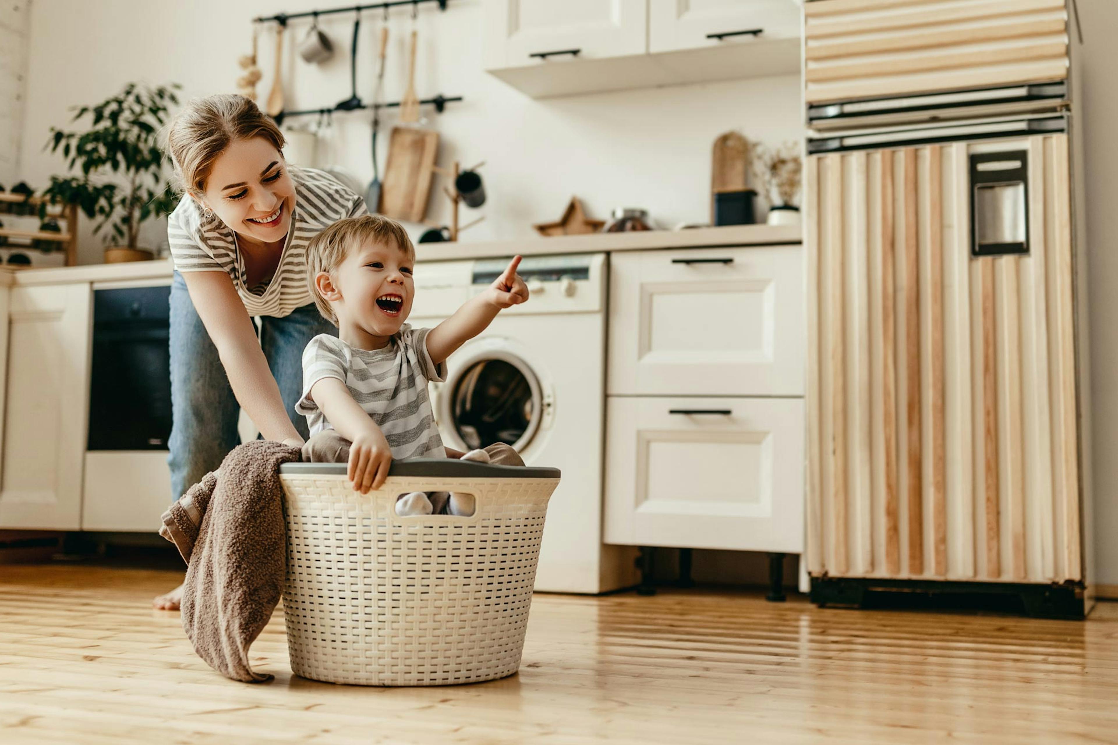 happy mom doing laundry with her son