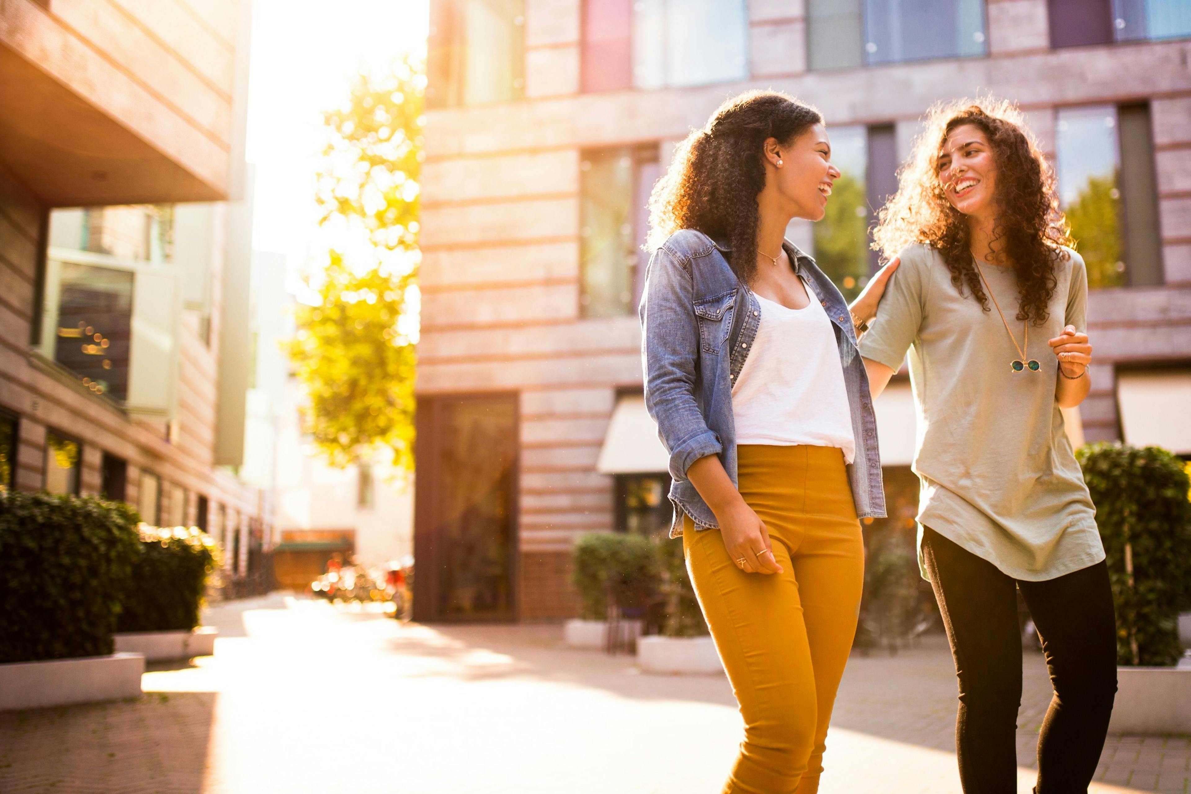 Happy friends walking together in the city