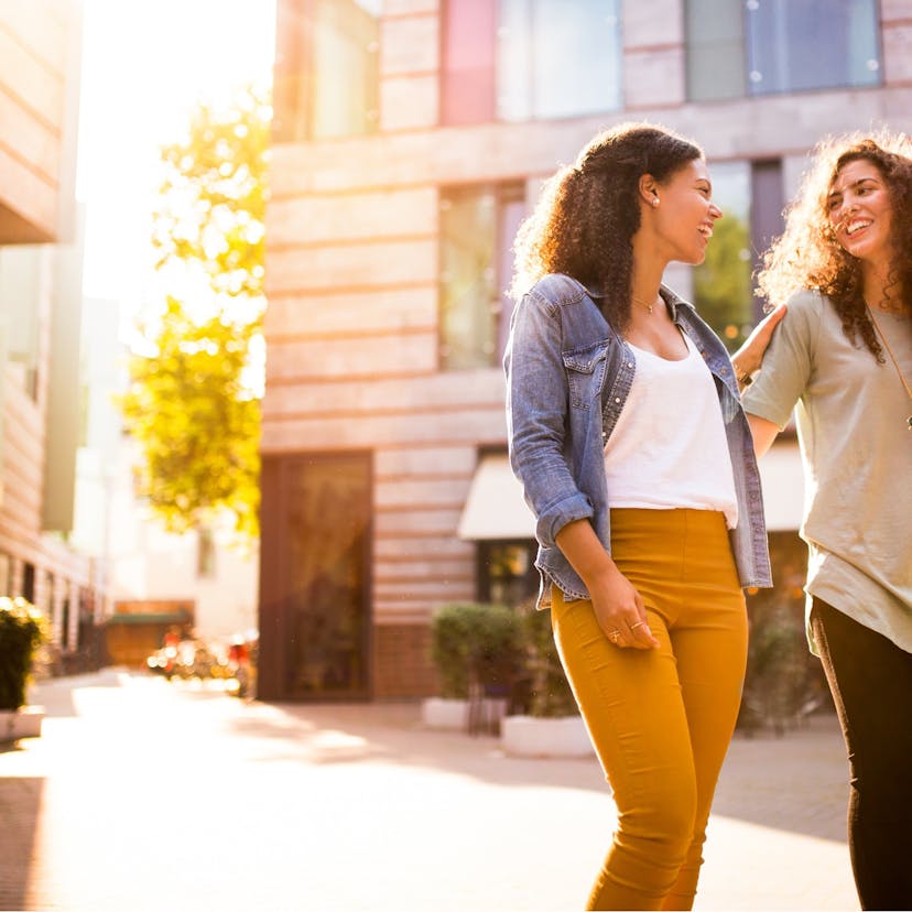 Happy friends walking together in the city