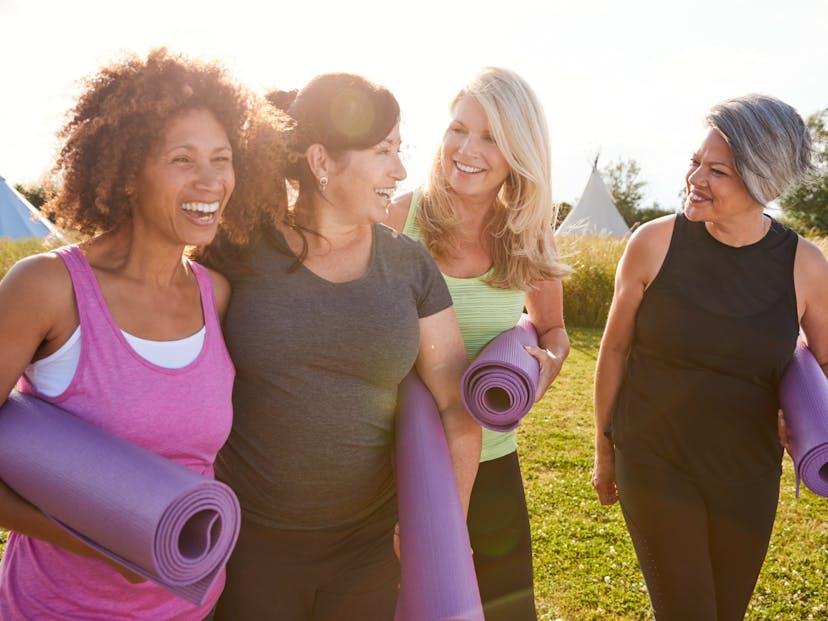 group of mature female friends on an outdoor yoga retreat