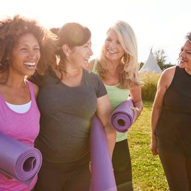 group of mature female friends on an outdoor yoga retreat