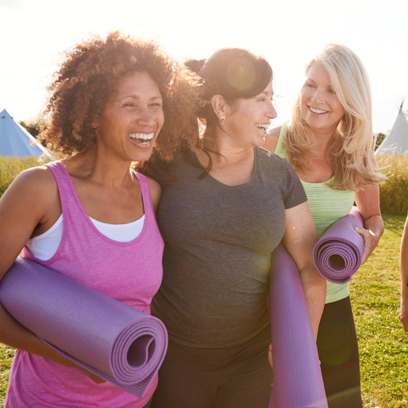 group of mature female friends on an outdoor yoga retreat