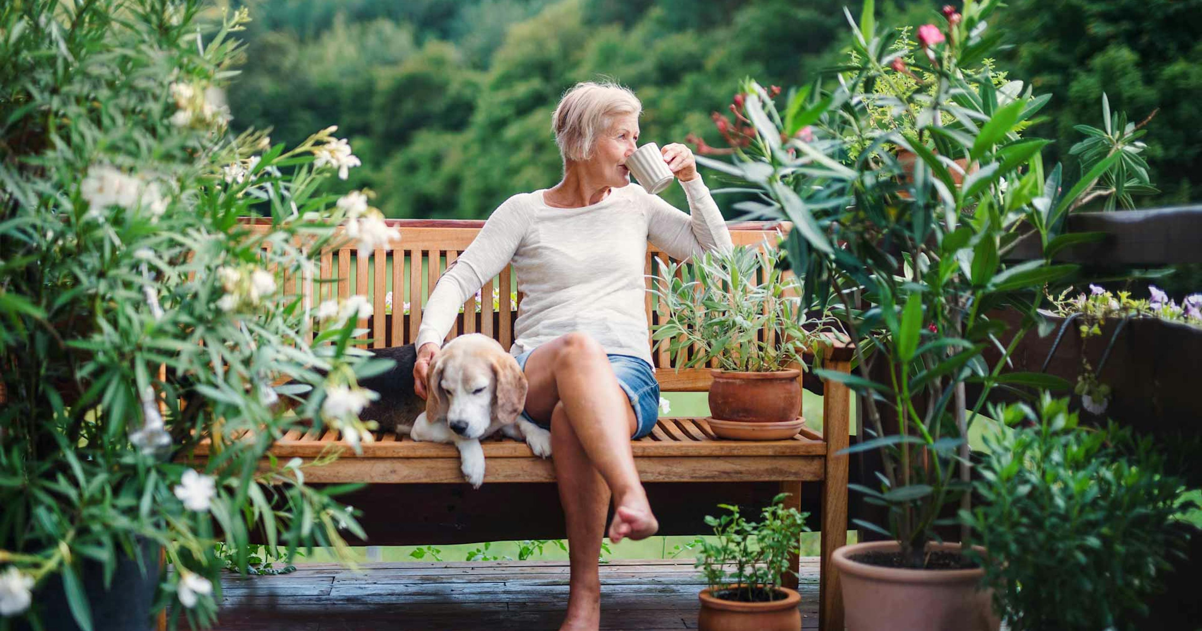 woman drinking coffee with her dog outside