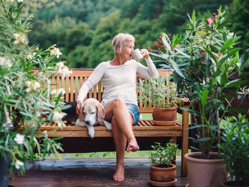 woman drinking coffee with her dog outside