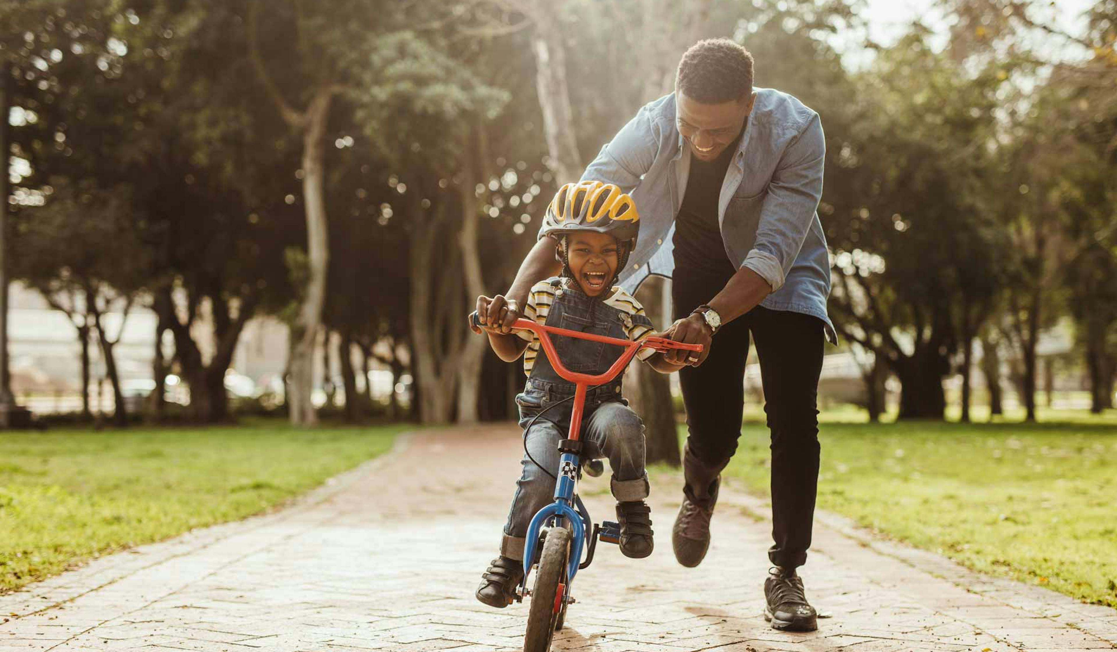 dad teaching son to ride a bike