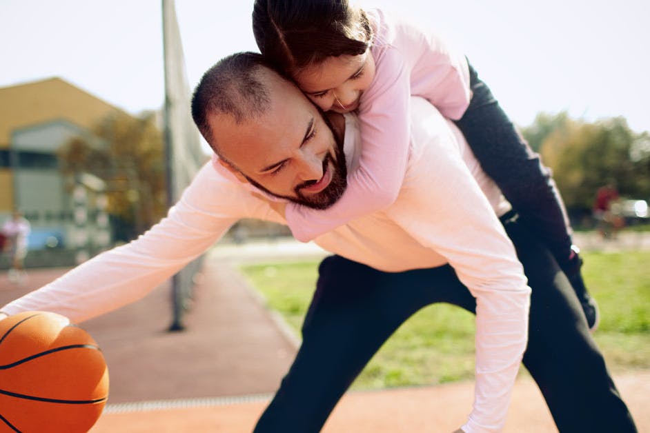 dad playing basketball with daughter