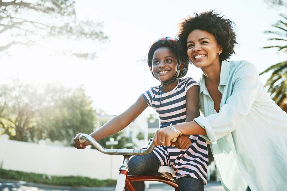 mom teaching daughter to ride a bike