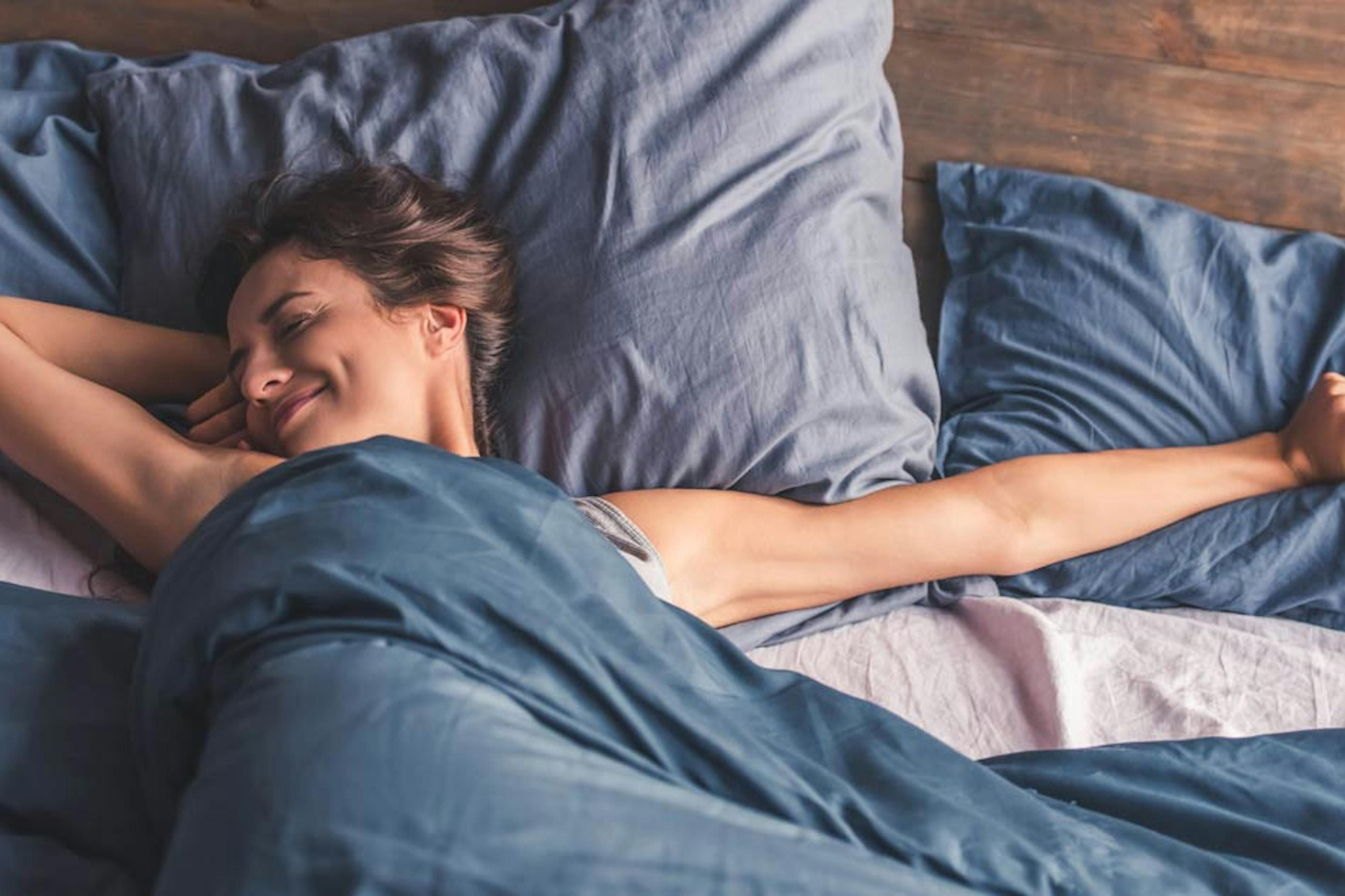 woman stretching in bed after a good night's sleep