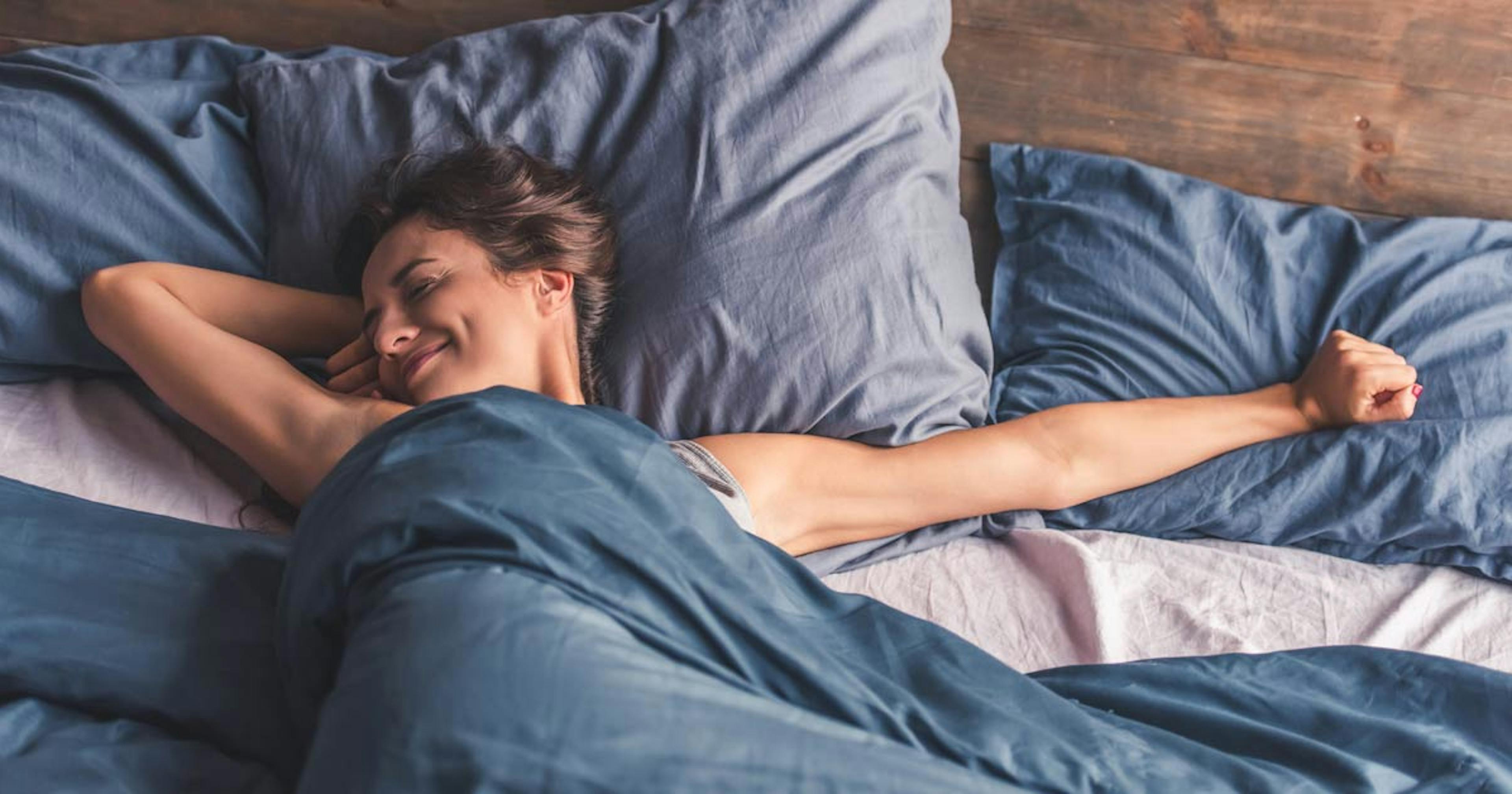 woman stretching in bed after a good night's sleep