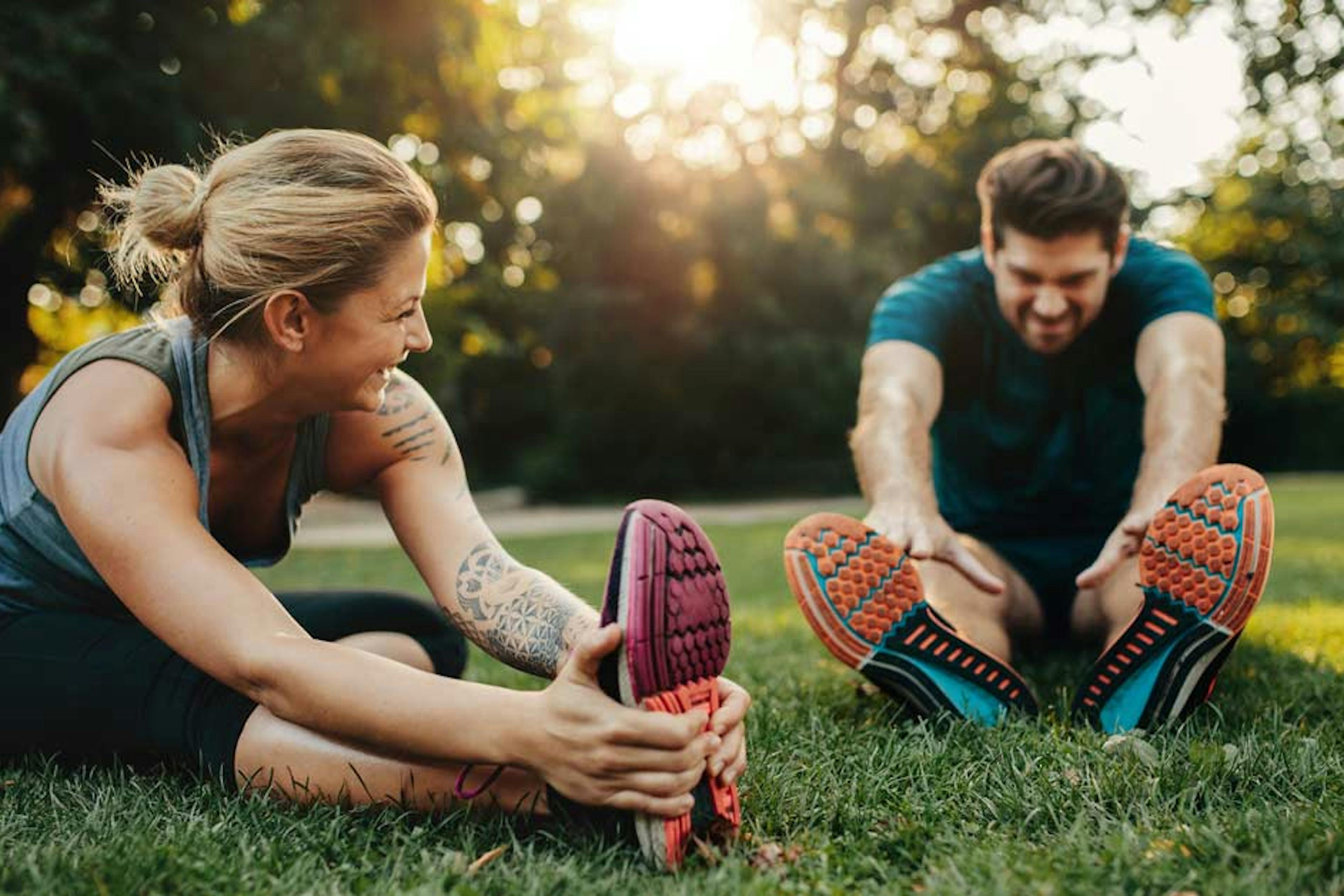 couple stretching outside after a workout