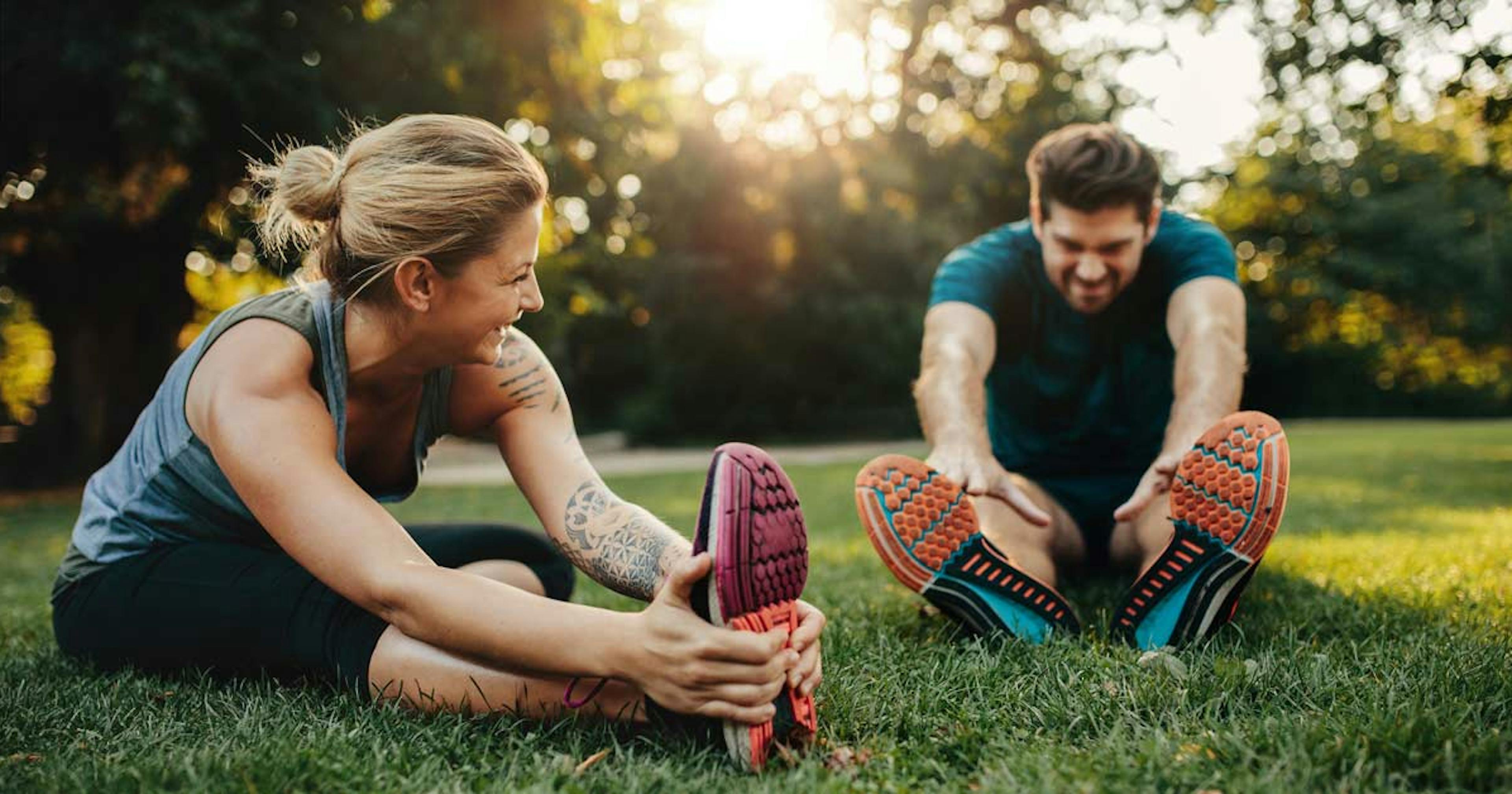 couple stretching outside after a workout