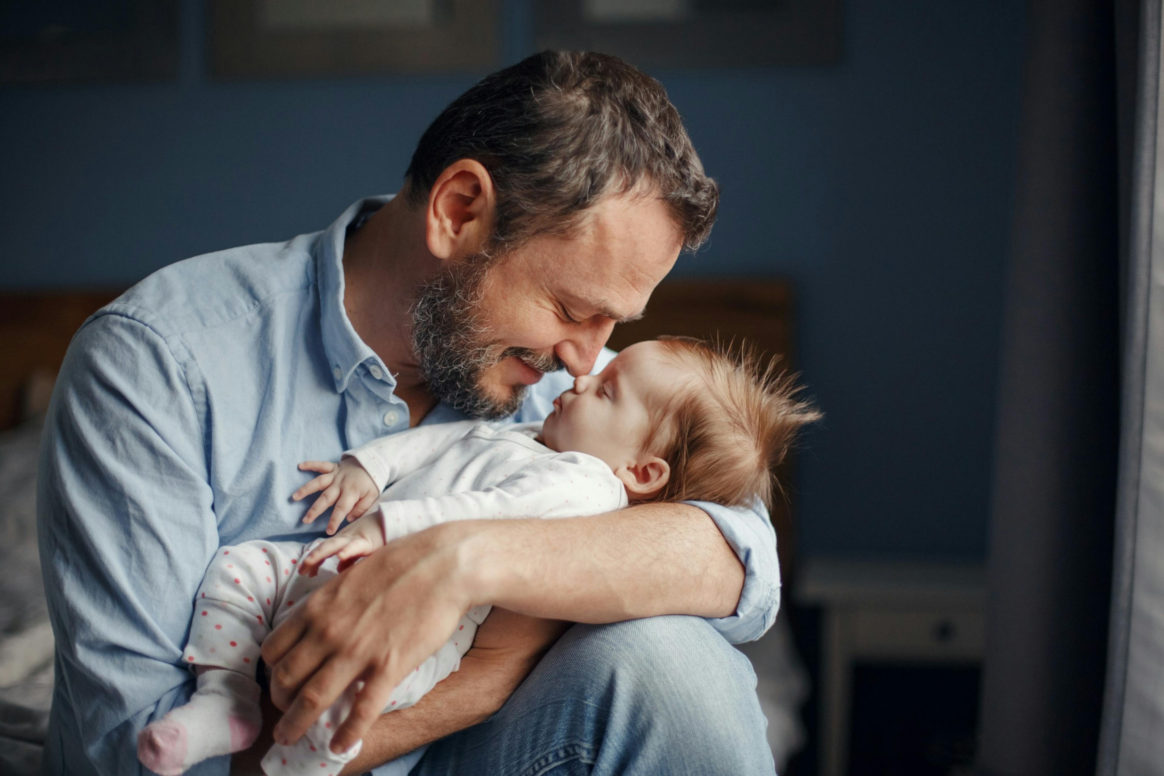 middle age dad kisses baby