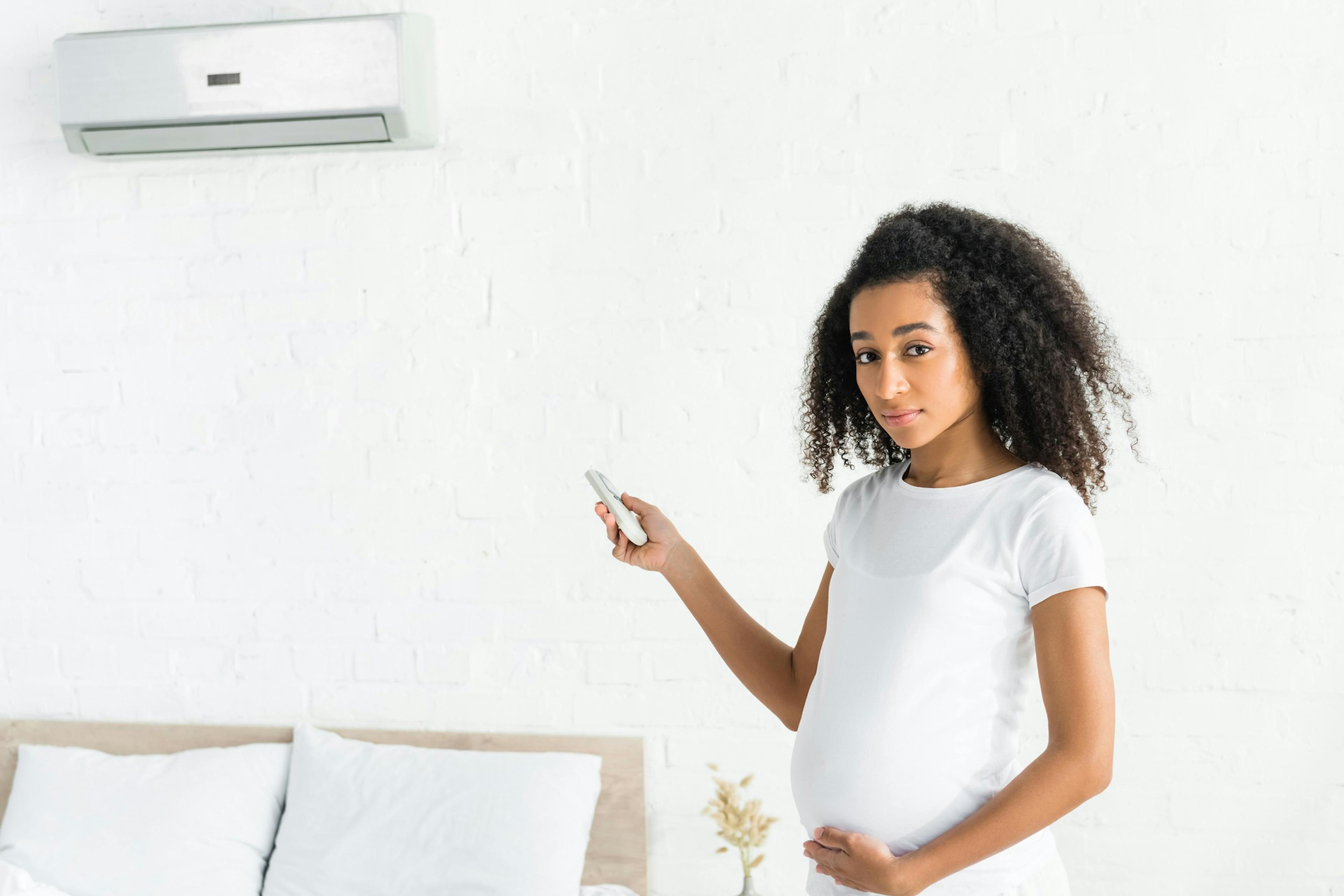 Pregnant woman turning on the AC