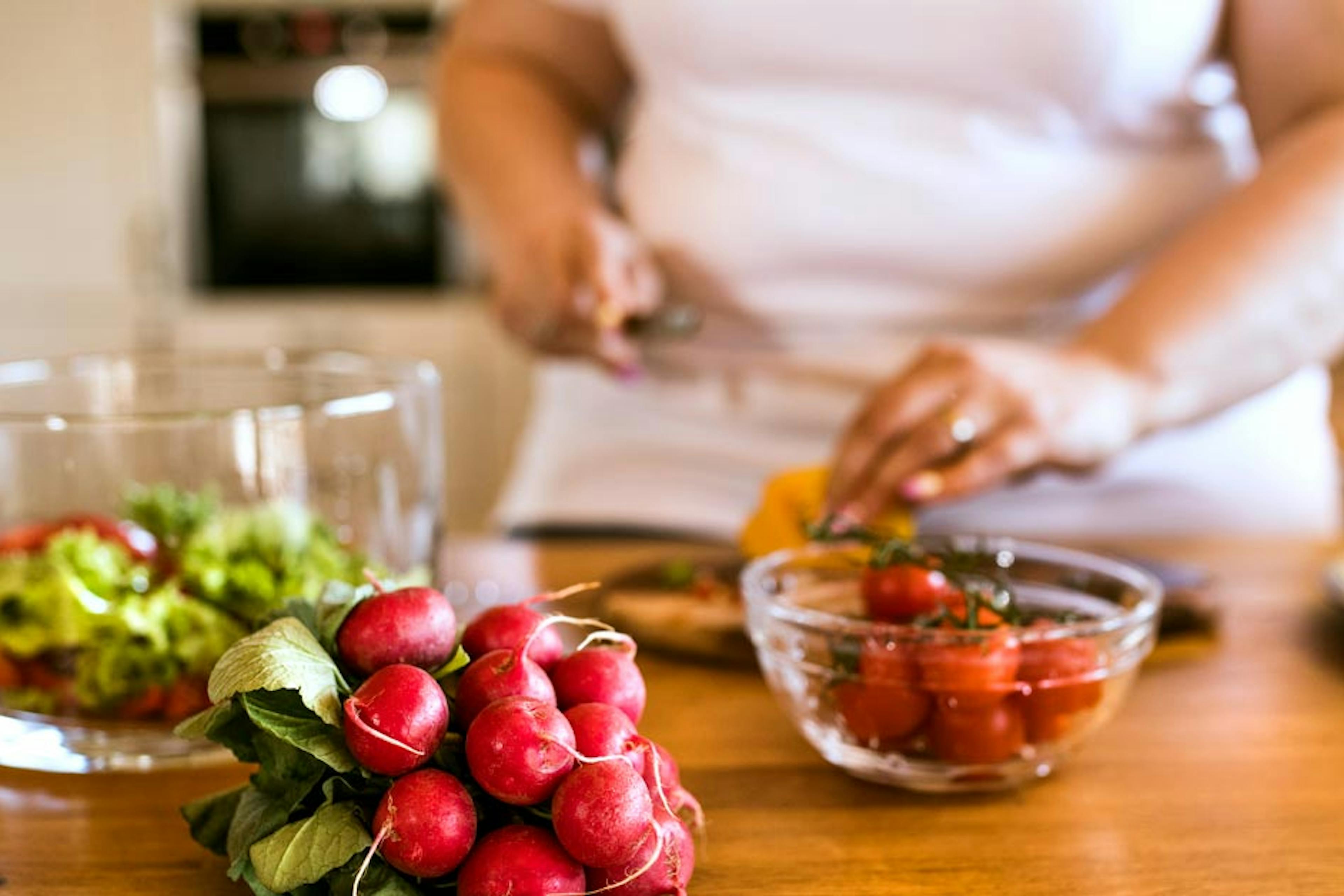 woman preparing a veggie-filled meal