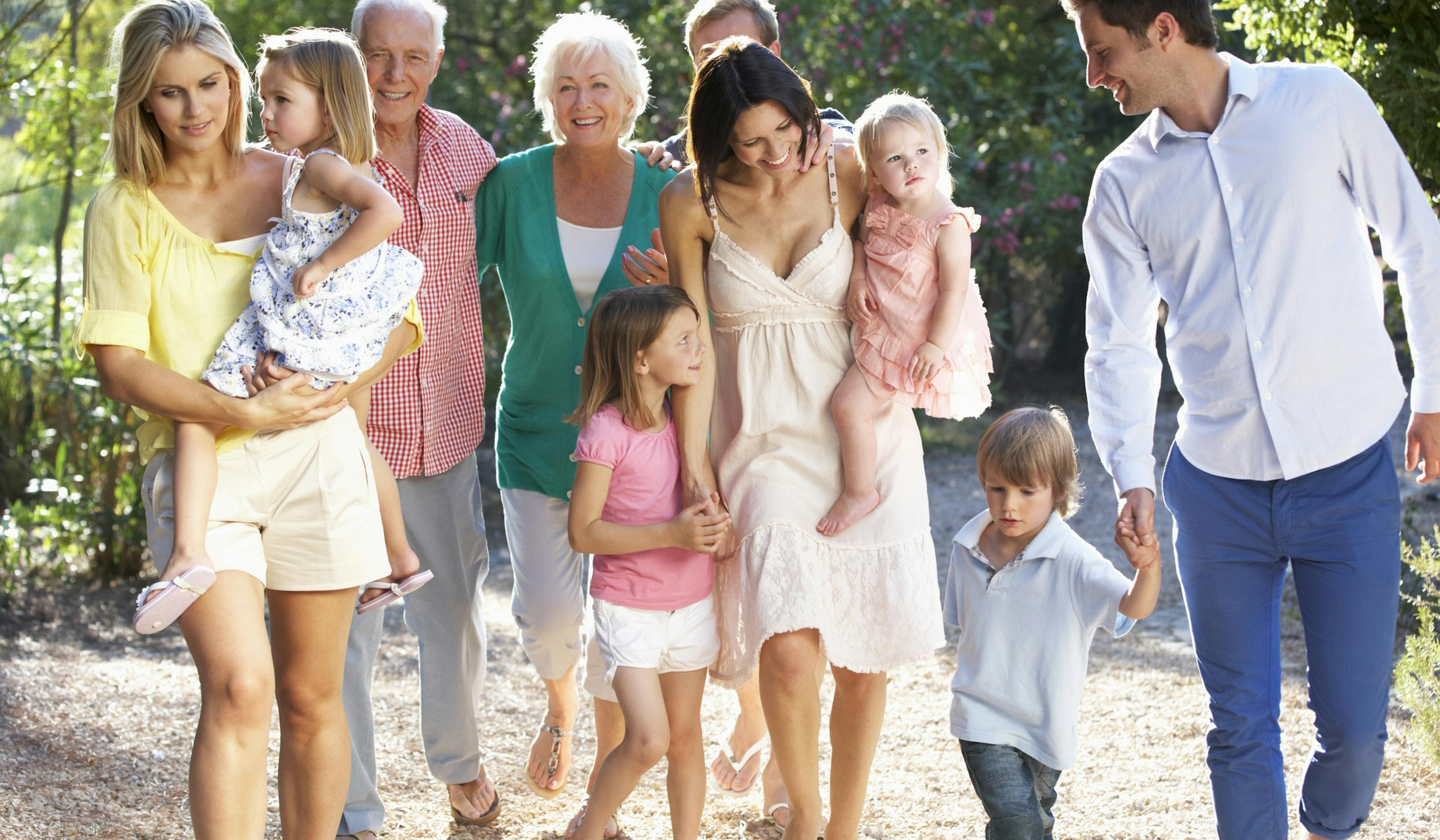 multi generational happy family walking in the sunshine