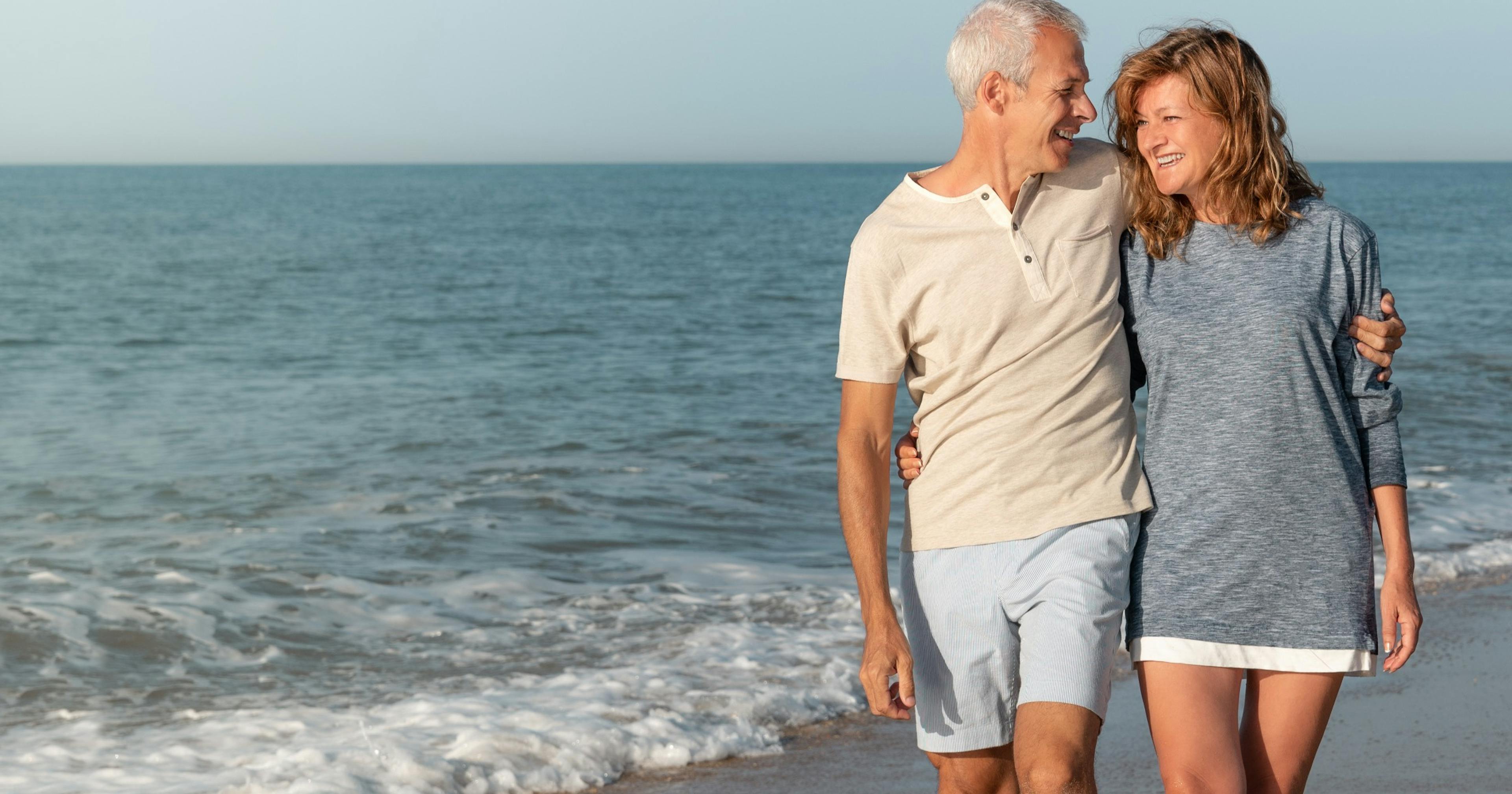 happy mature couple walking the beach