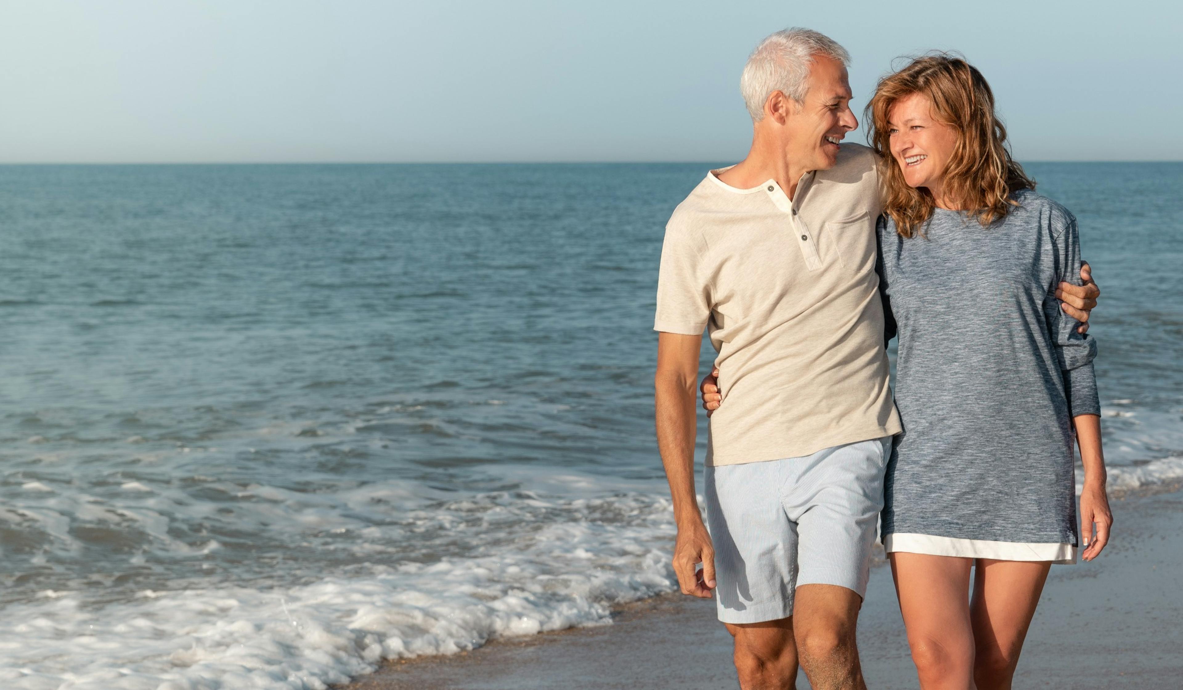 happy mature couple walking the beach