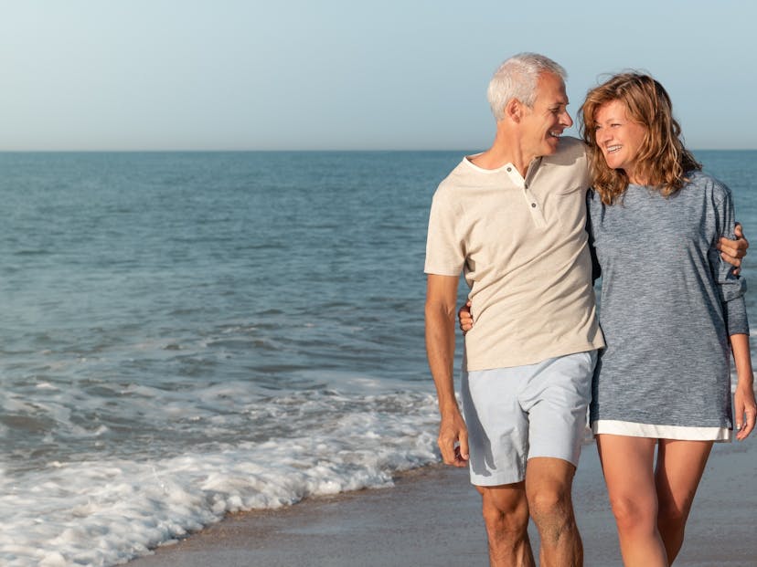 happy mature couple walking the beach