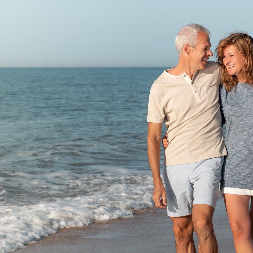 happy mature couple walking the beach