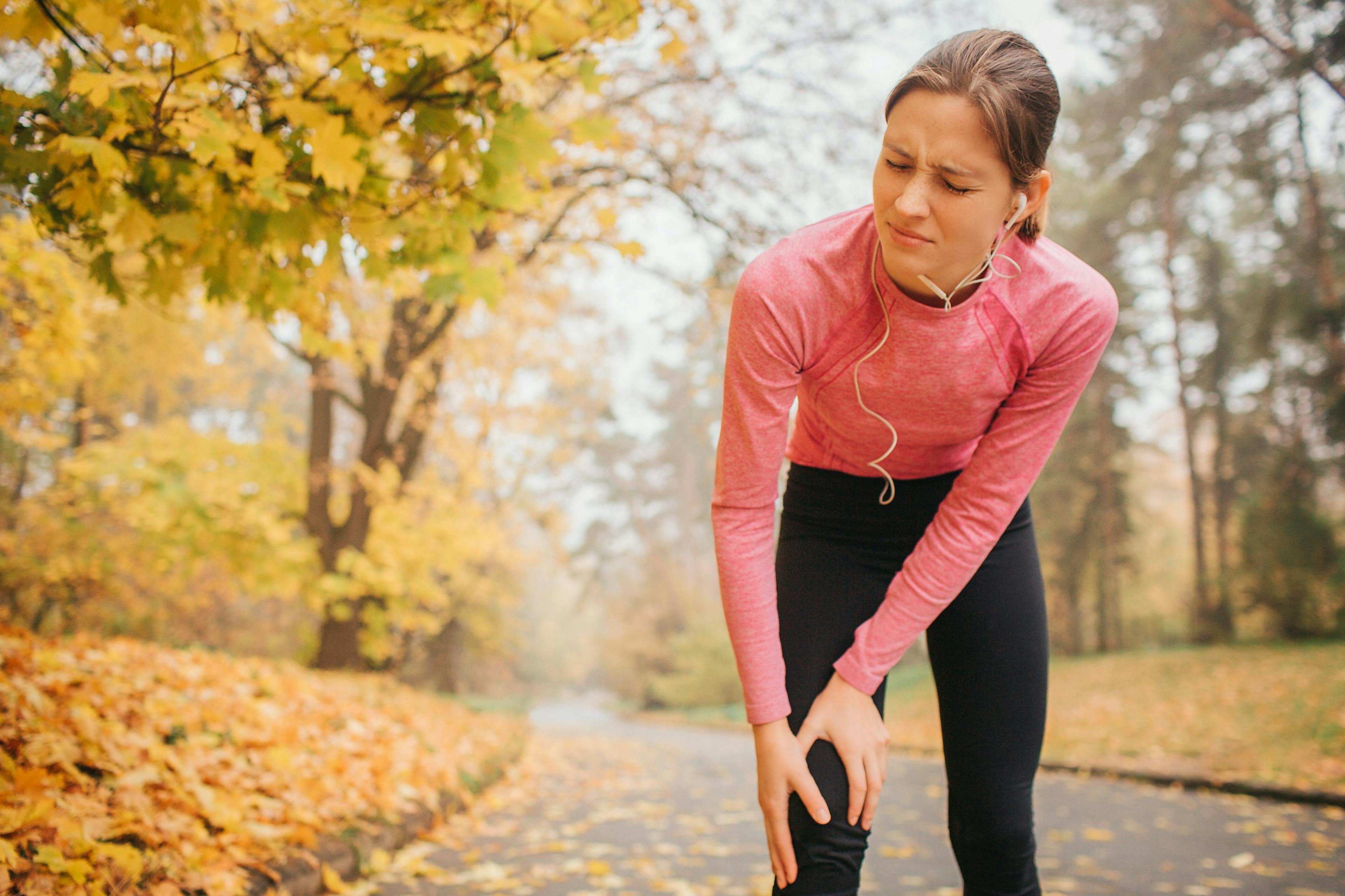 woman suffering from knee pain while on a run