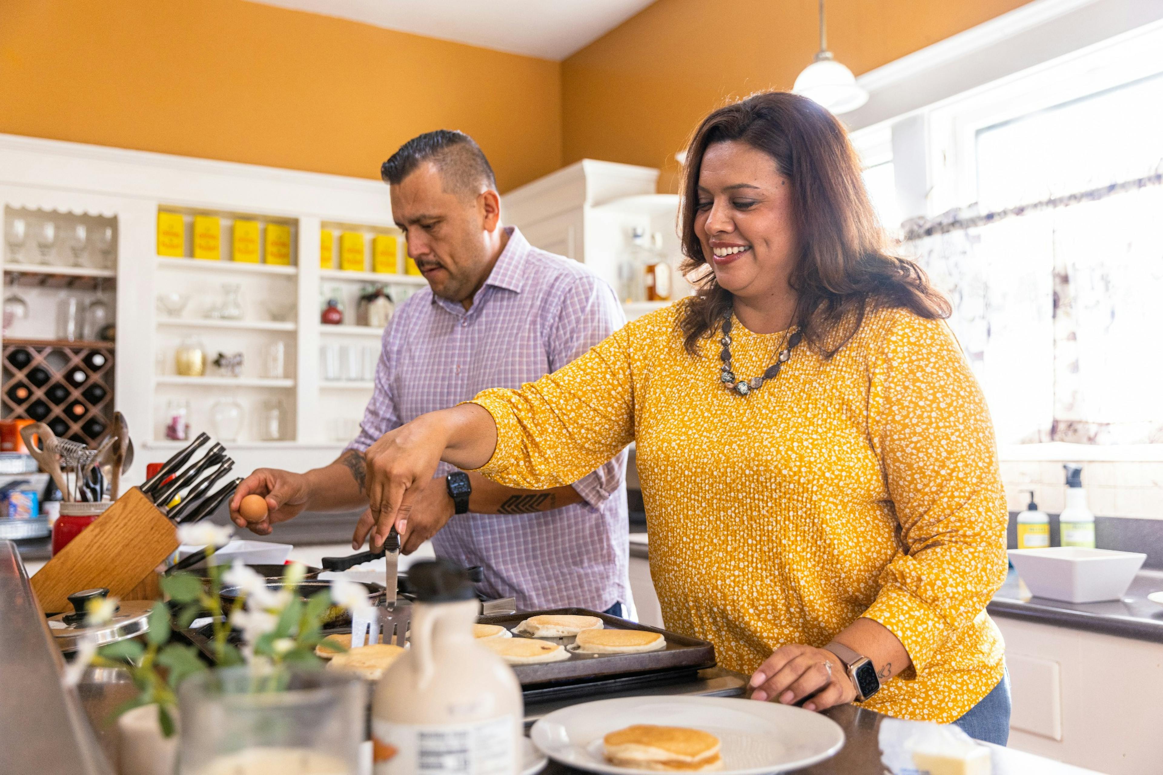 heavy set woman and husband make breakfast