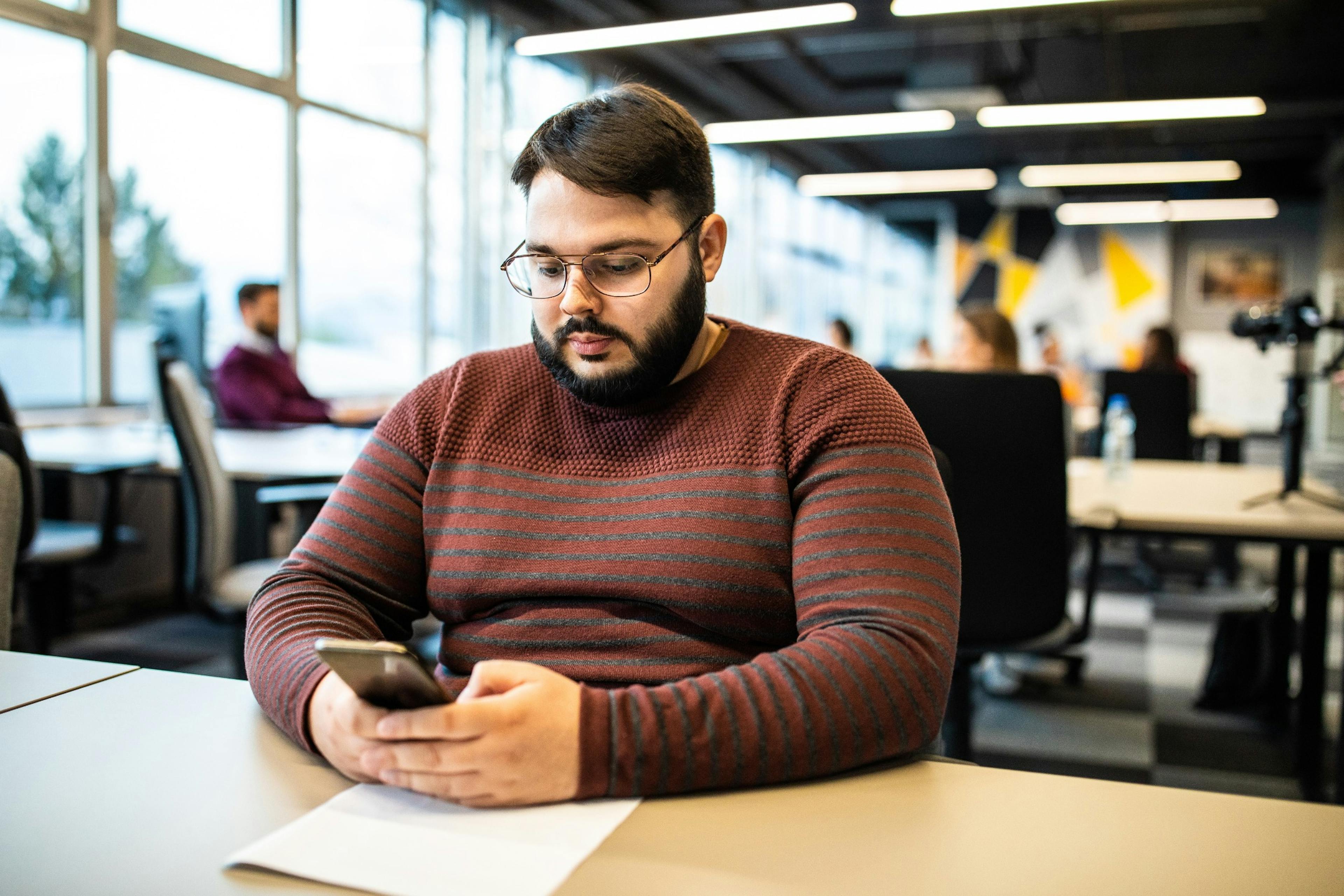 overweight man texting at work