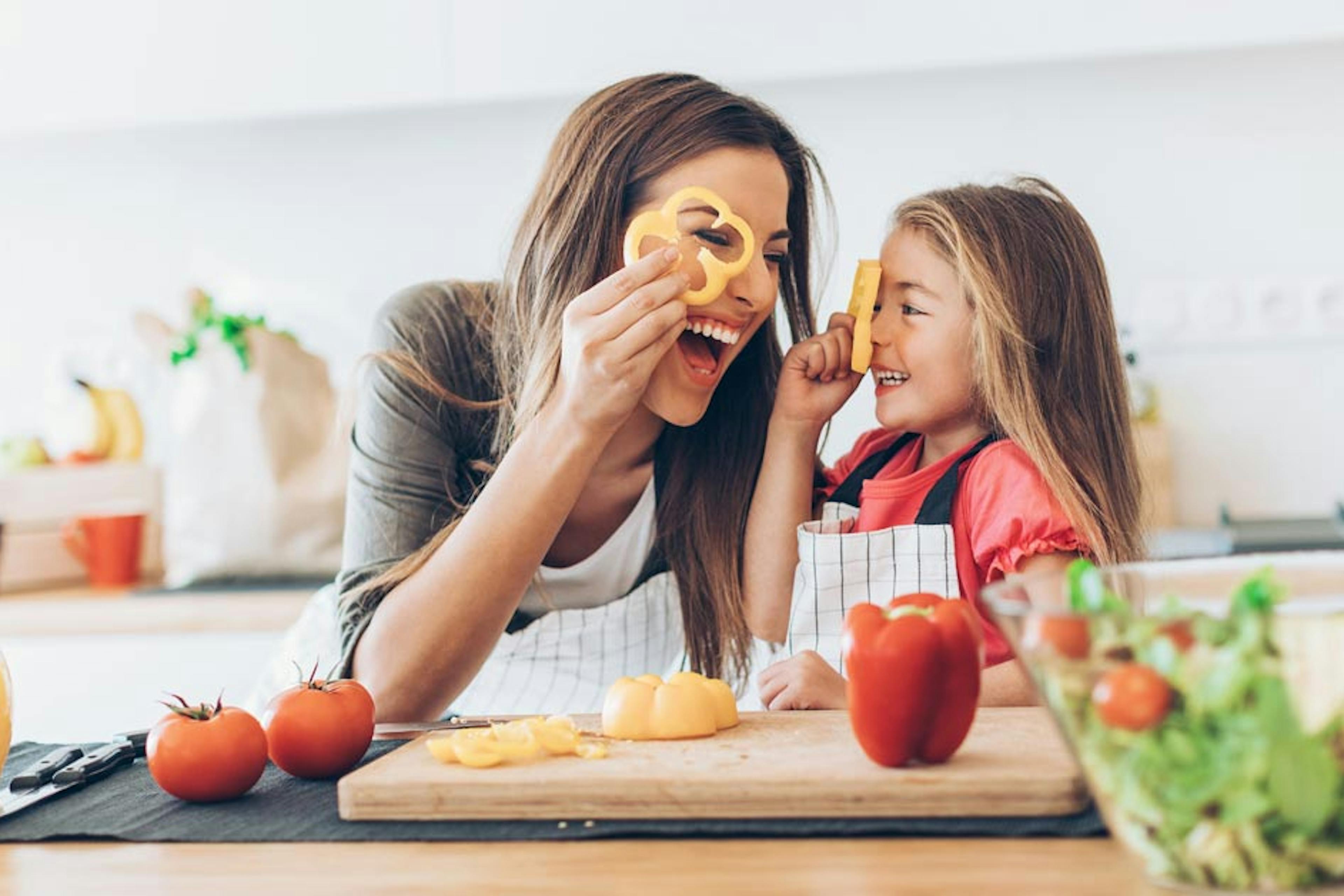 mom and daughter chipping veggies in the kitchen